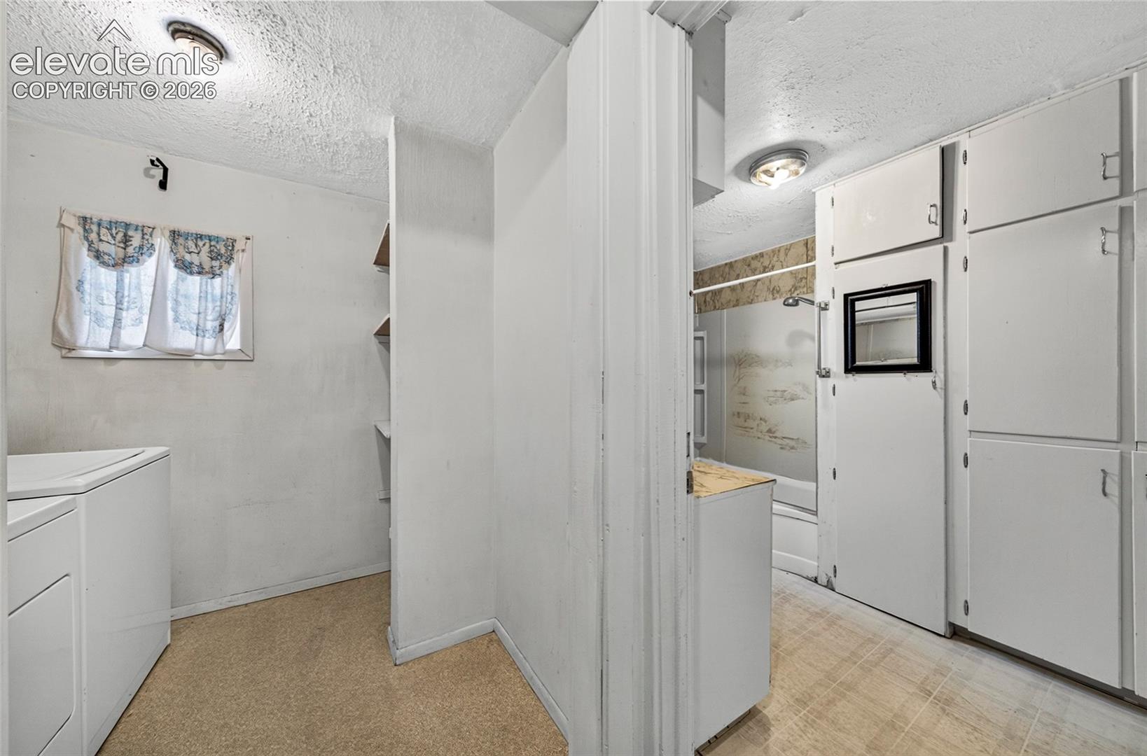 Laundry room and bathroom next to each other