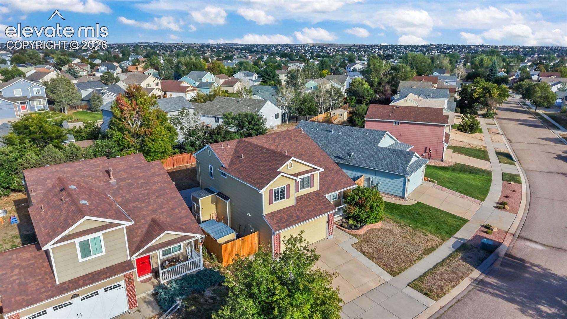 Suburban setting featuring an asphalt street, concrete sidewalks, and a varied roofline