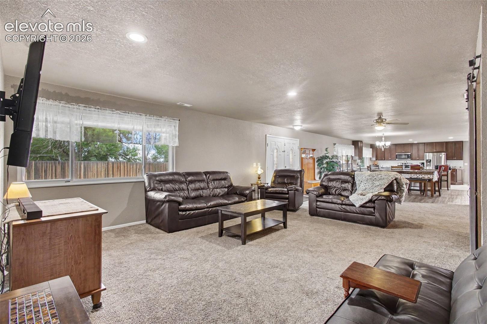 Welcoming living room just off the entry, featuring an open-concept layout that seamlessly flows into the dining area and kitchen.