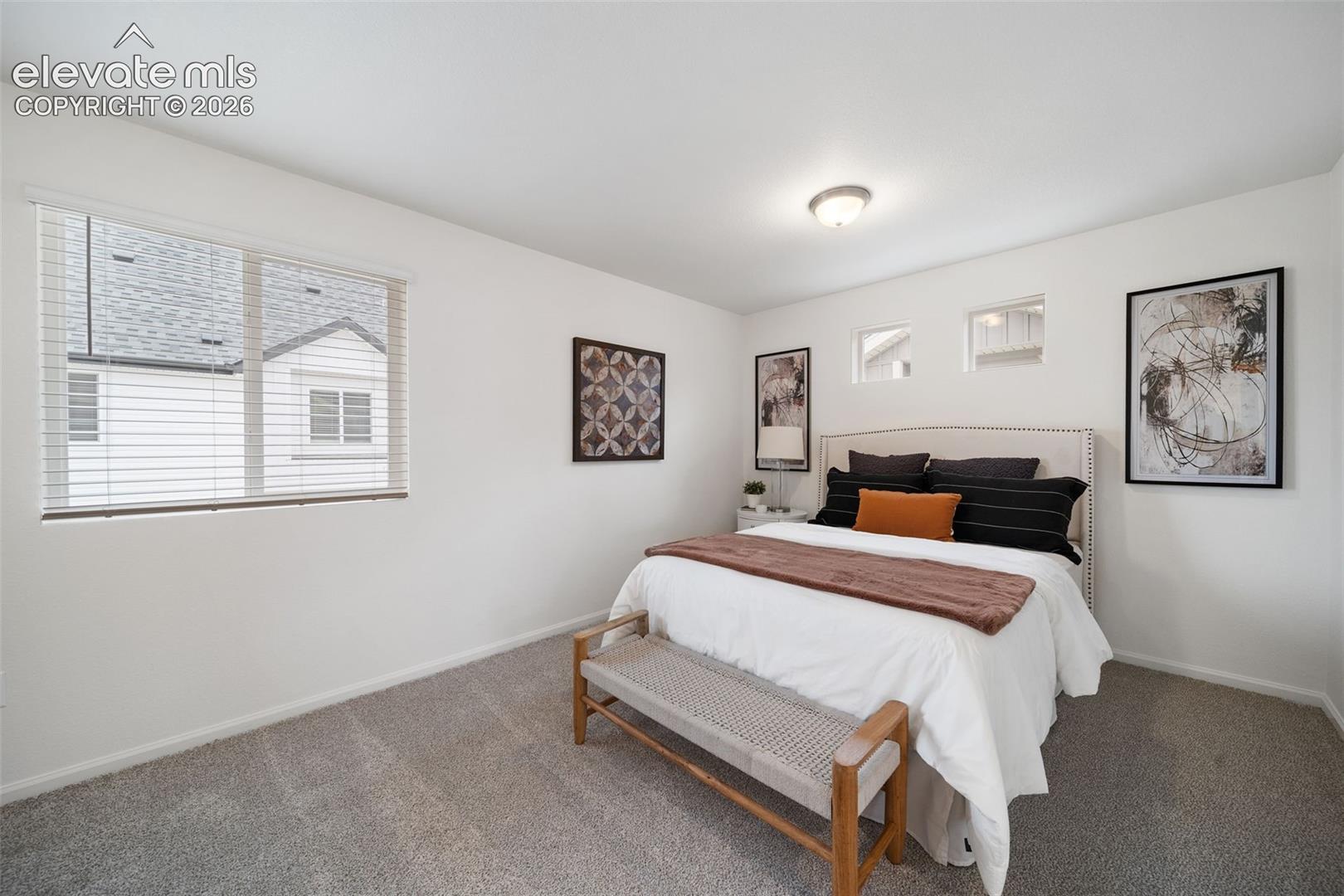 Carpeted room with a flush-mount ceiling light and white walls
*photos of a model home*