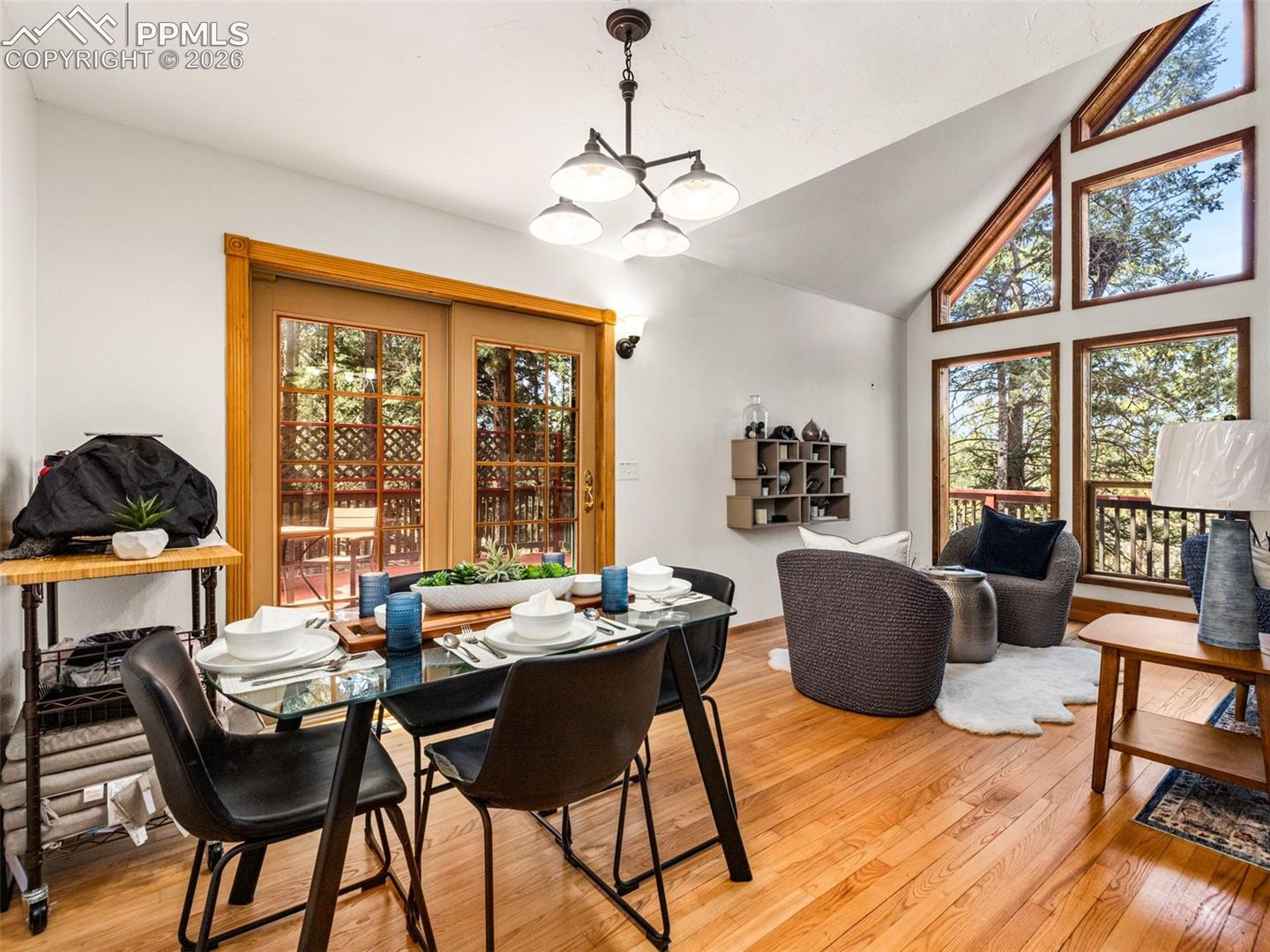 Dining area with lofted ceiling, light wood-style flooring, and hanging lights