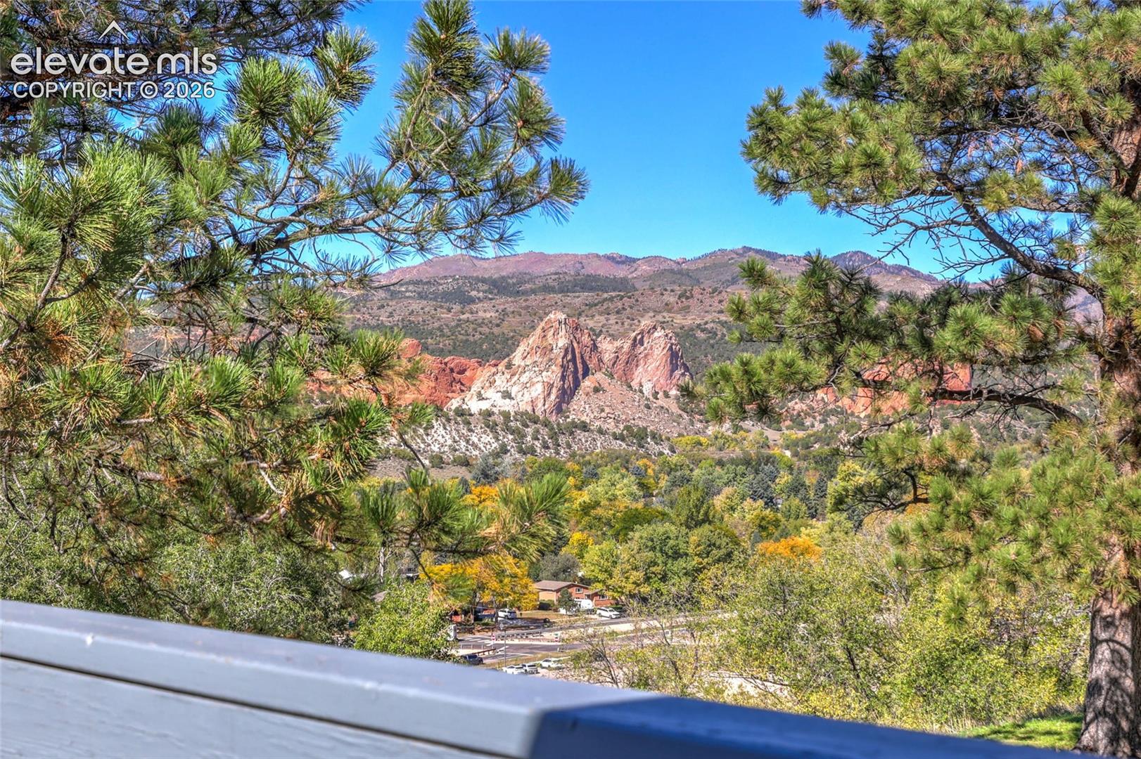 Mountain backdrop featuring rock formations, mature pine trees, and native vegetation