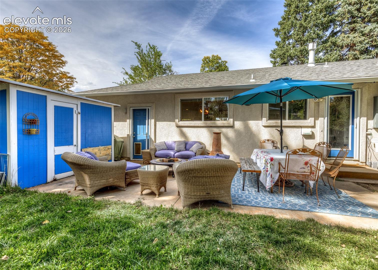 Expansive concrete patio with direct outdoor access and a detached storage shed