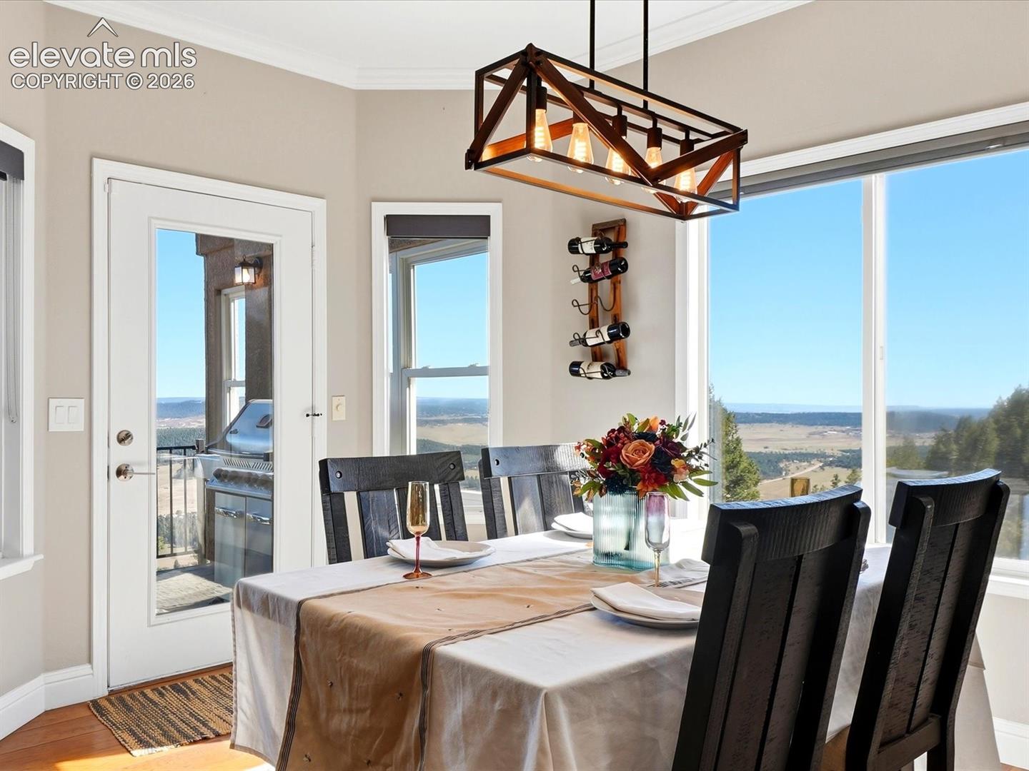 Rectangular chandelier with a metal and wood-finish frame, expansive glass windows, and a full-light glass door