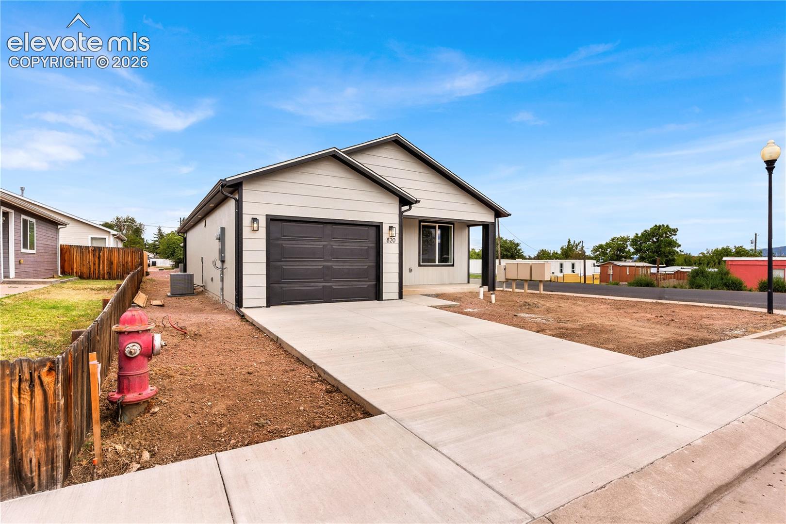 Single-story exterior featuring horizontal siding, a gabled roofline, an attached one-car garage, and a paved concrete driveway