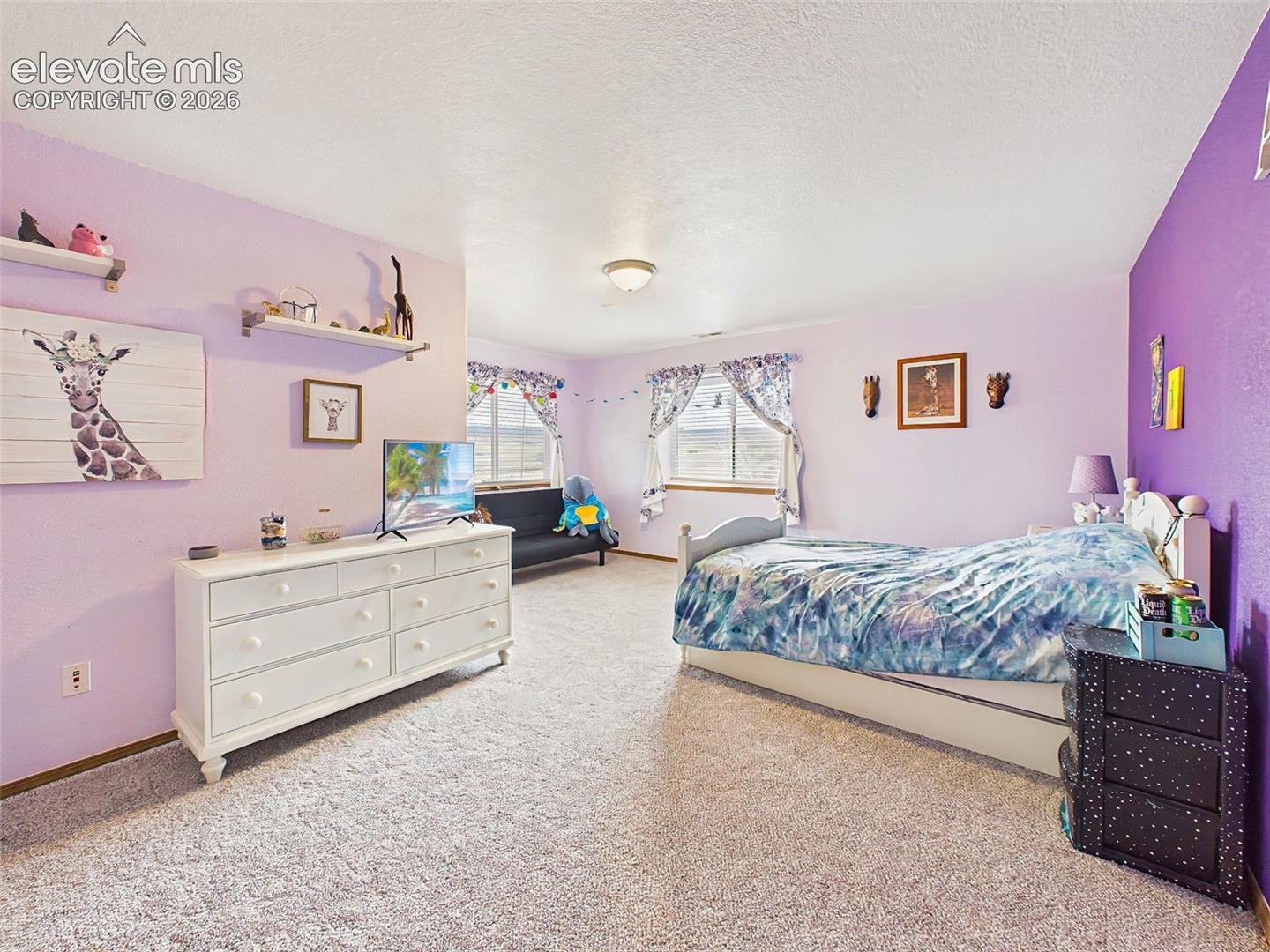 Comfortable Lower level bedroom featuring ample natural light, neutral carpeting, and a flexible layout with large walk in closet.