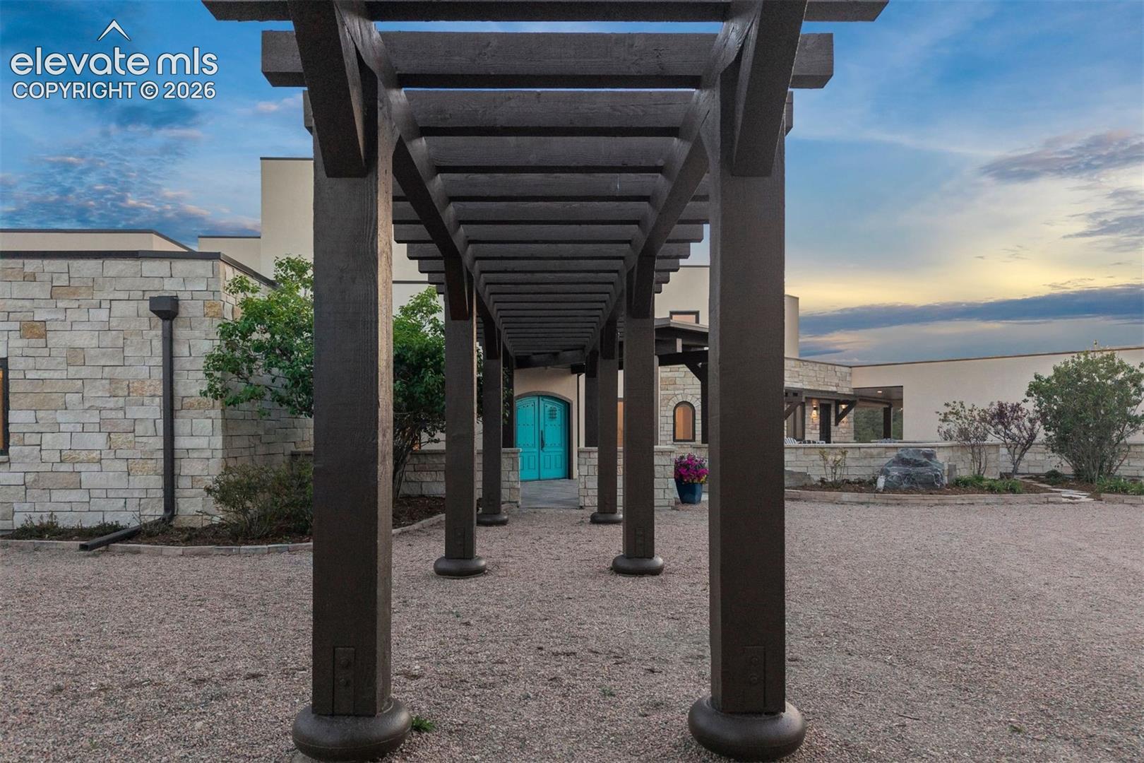 Pergola pathway leads to the symbolic, arched turquoise doors.