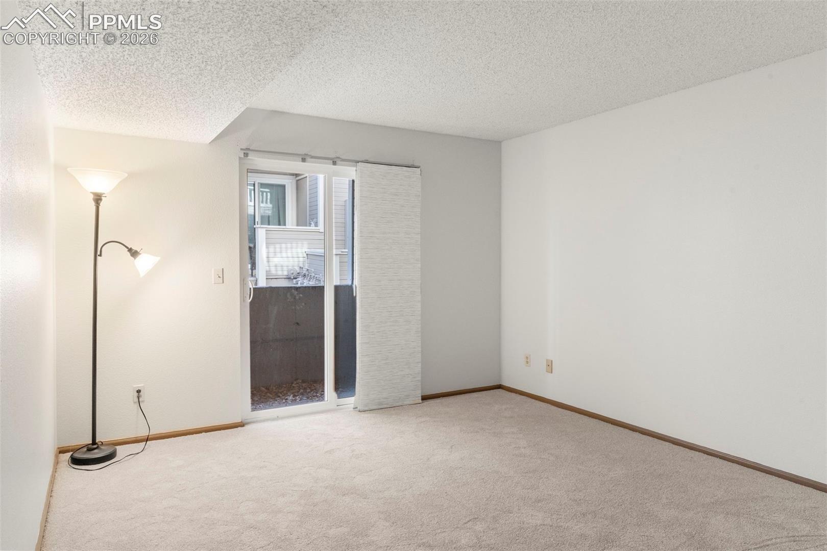 Unfurnished bedroom with a textured ceiling and light carpet