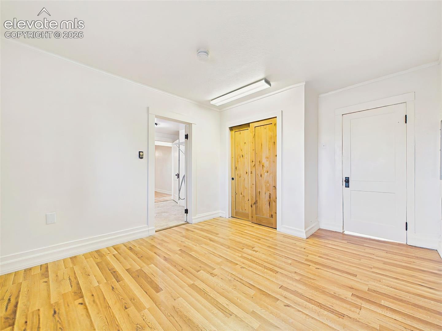 Primary Bedroom – Bright primary bedroom showcases floors, rustic sliding closet doors, and easy access to the updated en-suite.