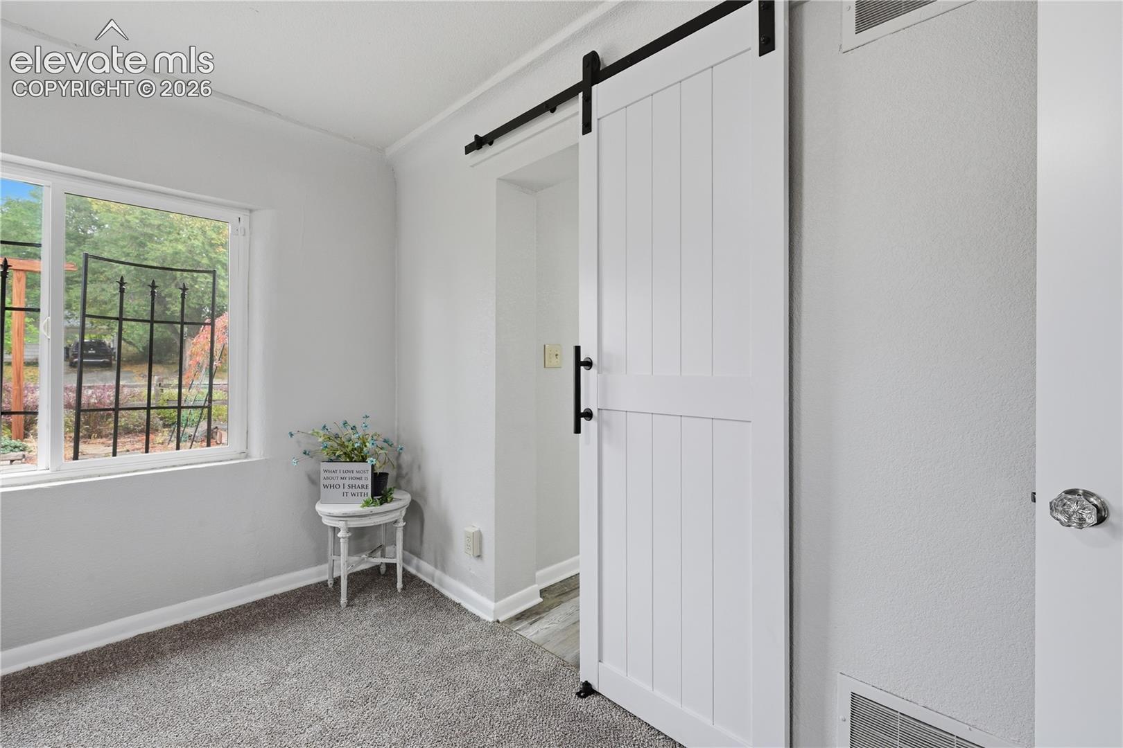 A private barn door entrance to the main level bathroom from the primary bedroom.