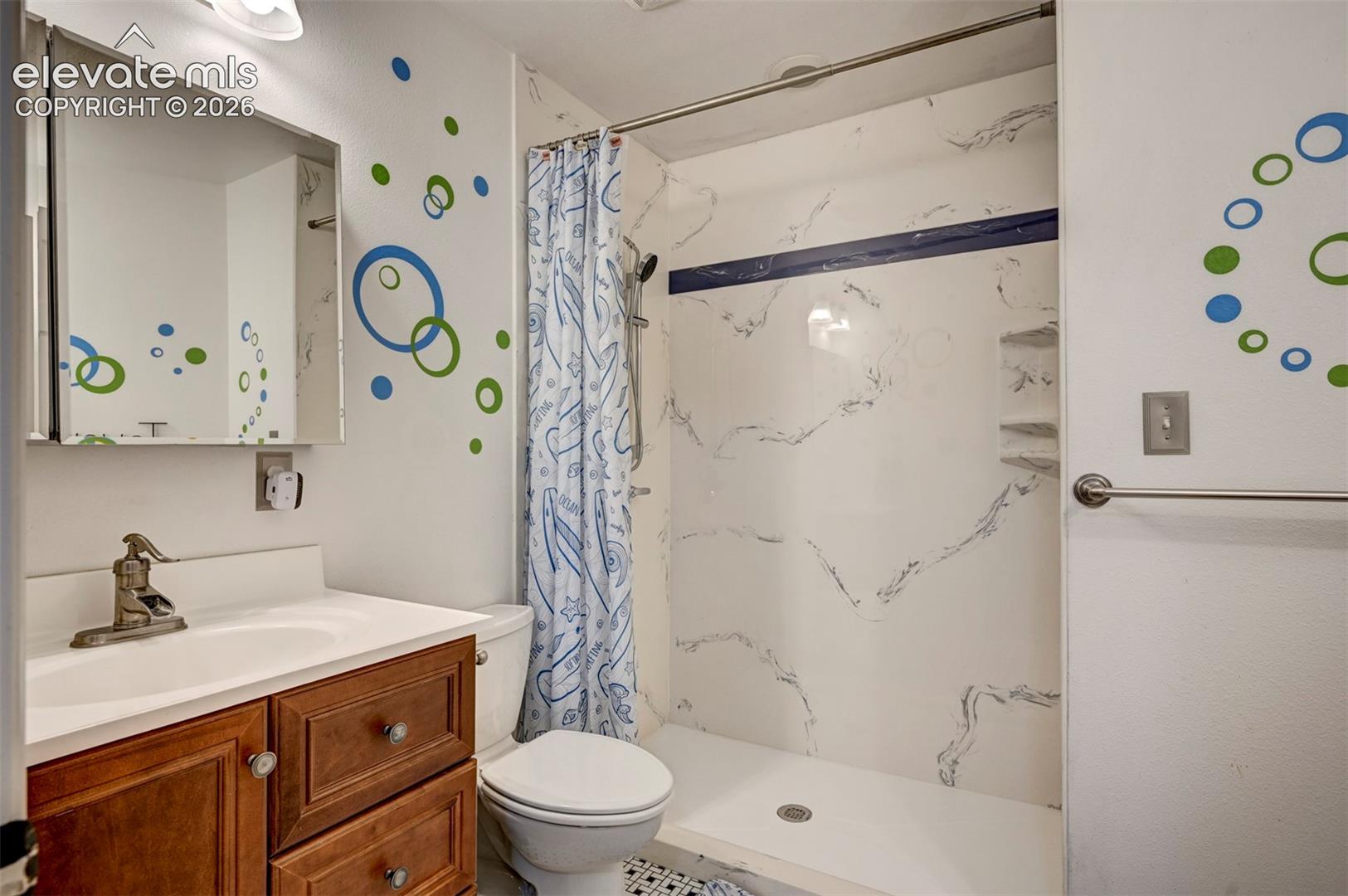 Vanity with wood-finish cabinetry, white countertop, and integrated sink