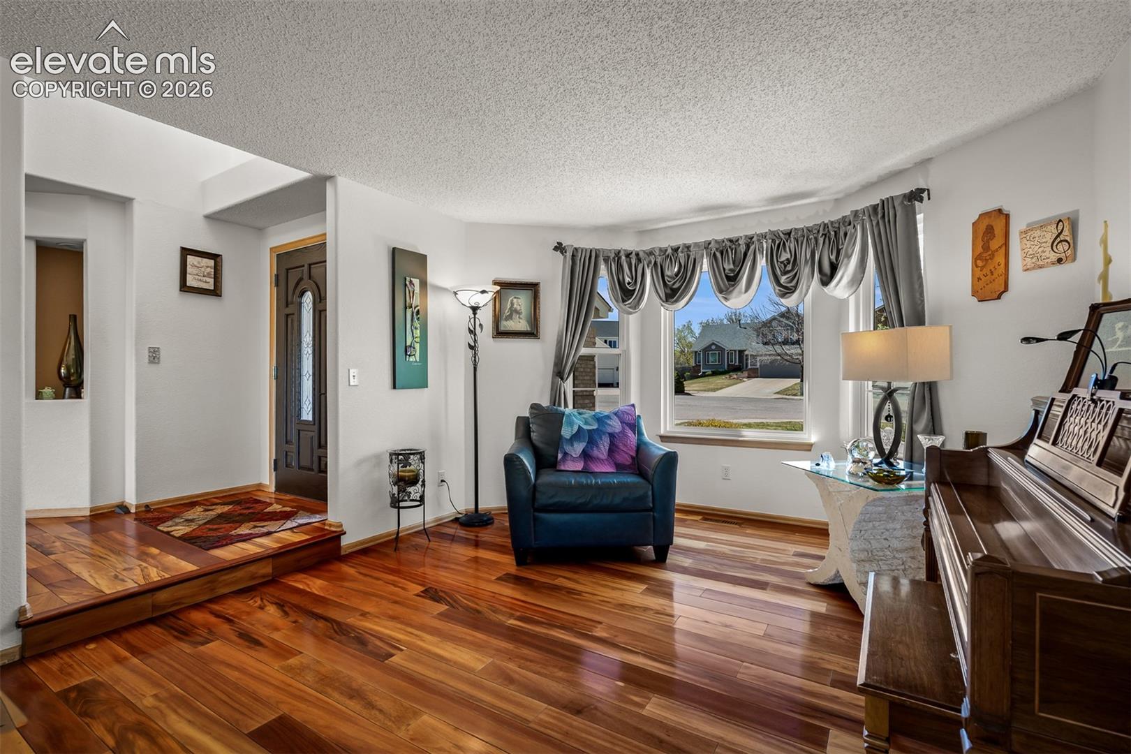 Warm Brazilian Koa Hardwood flooring throughout, featuring a front bay window with lots of natural light.