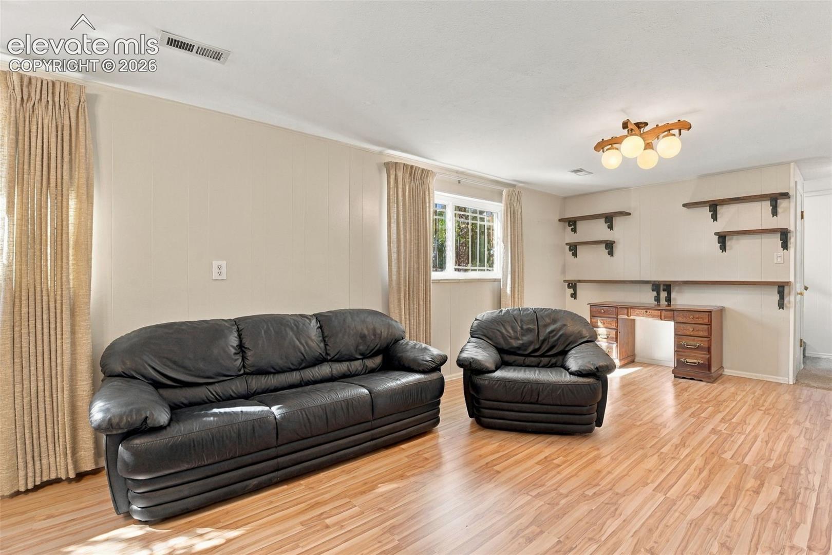 Wood-finish flooring, multi-light ceiling fixture, and built-in wall shelving