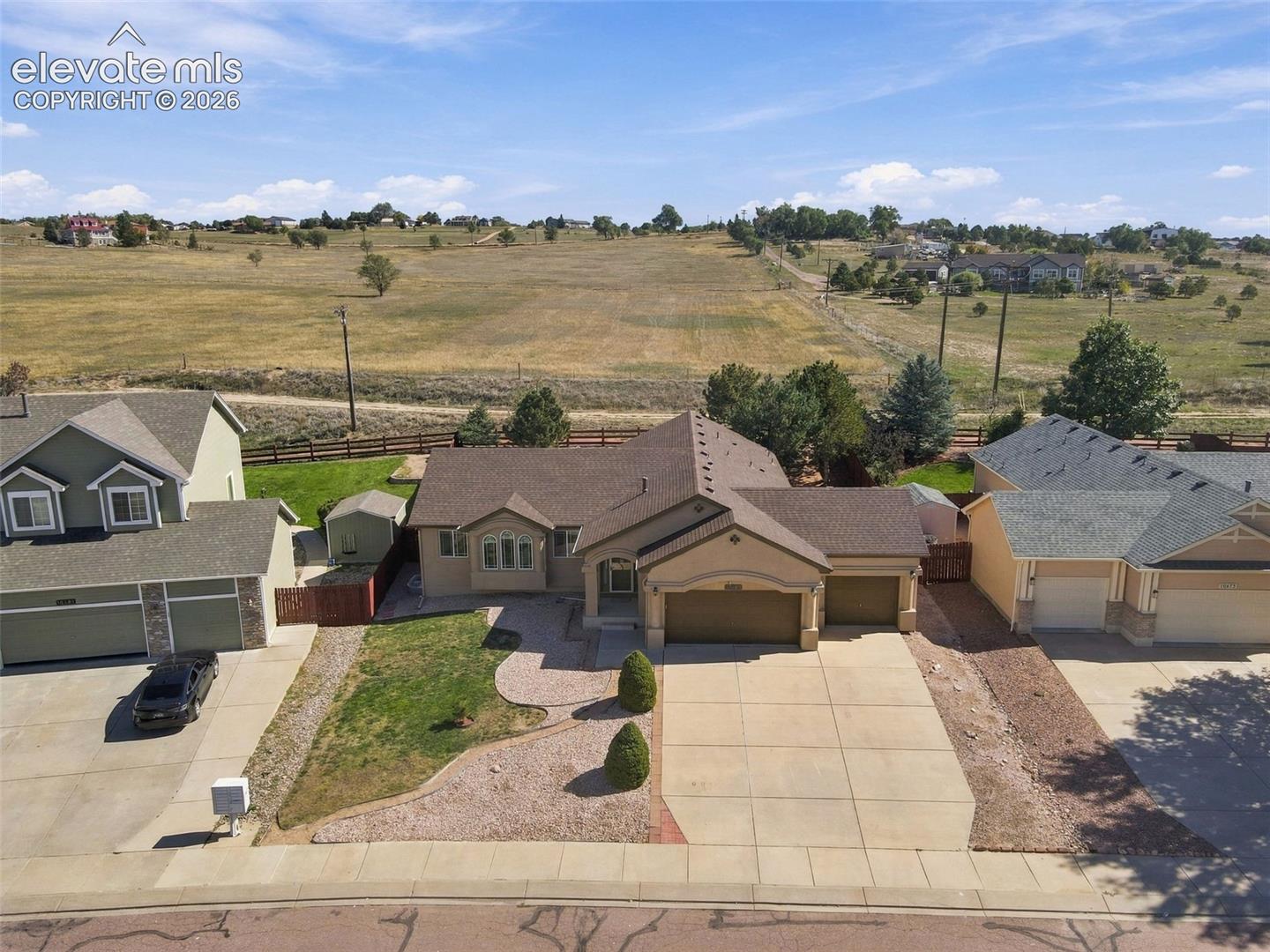 Single-story property with an attached two-car garage, a paved driveway, and a stone-lined walkway