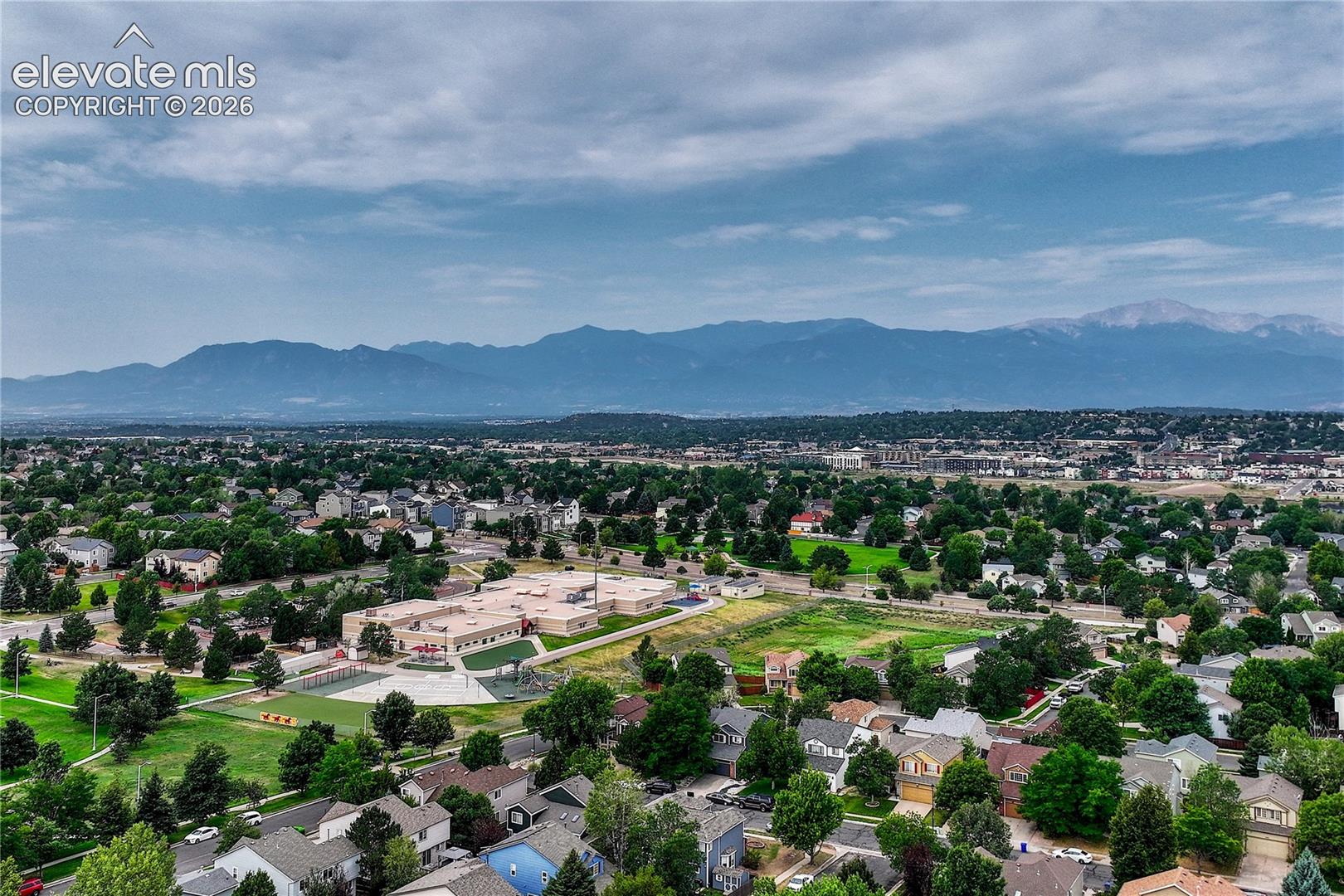 Aerial perspective featuring expansive mountain range scenery and surrounding residential green space