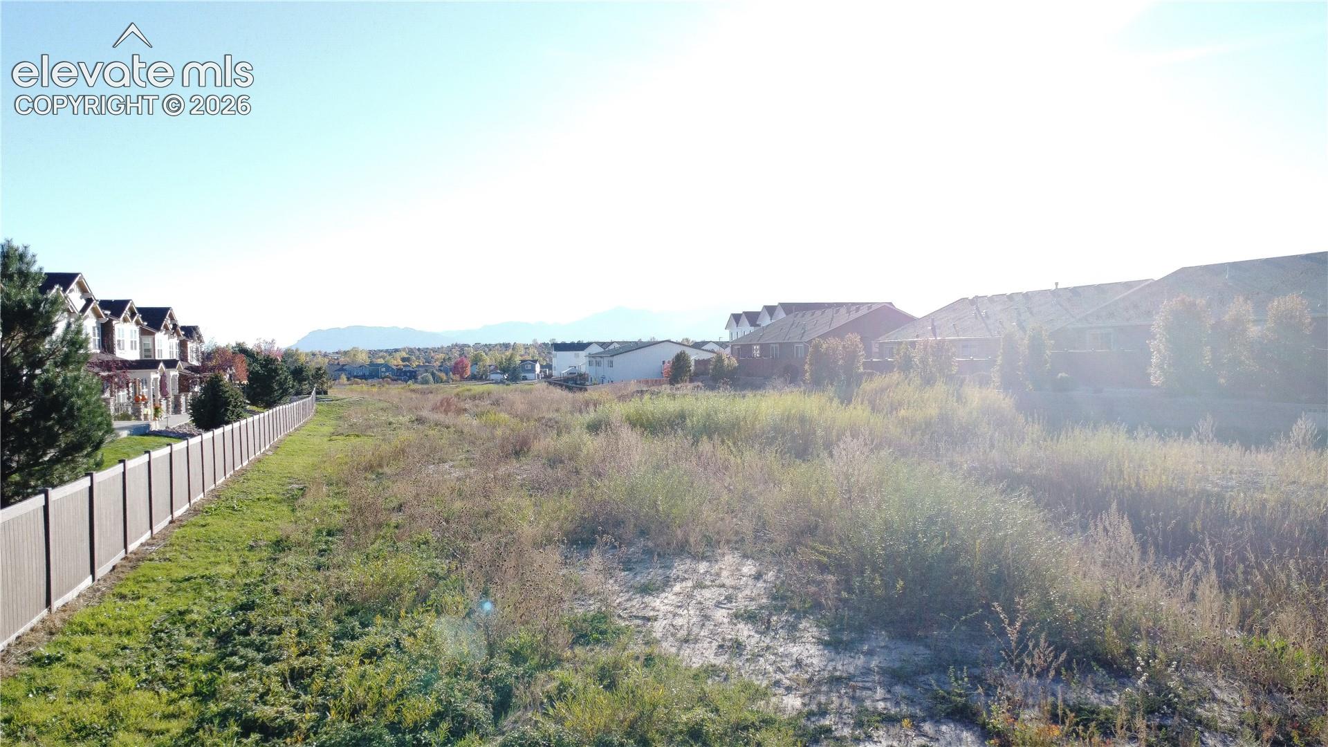 Open space featuring mountain backdrops and perimeter fencing