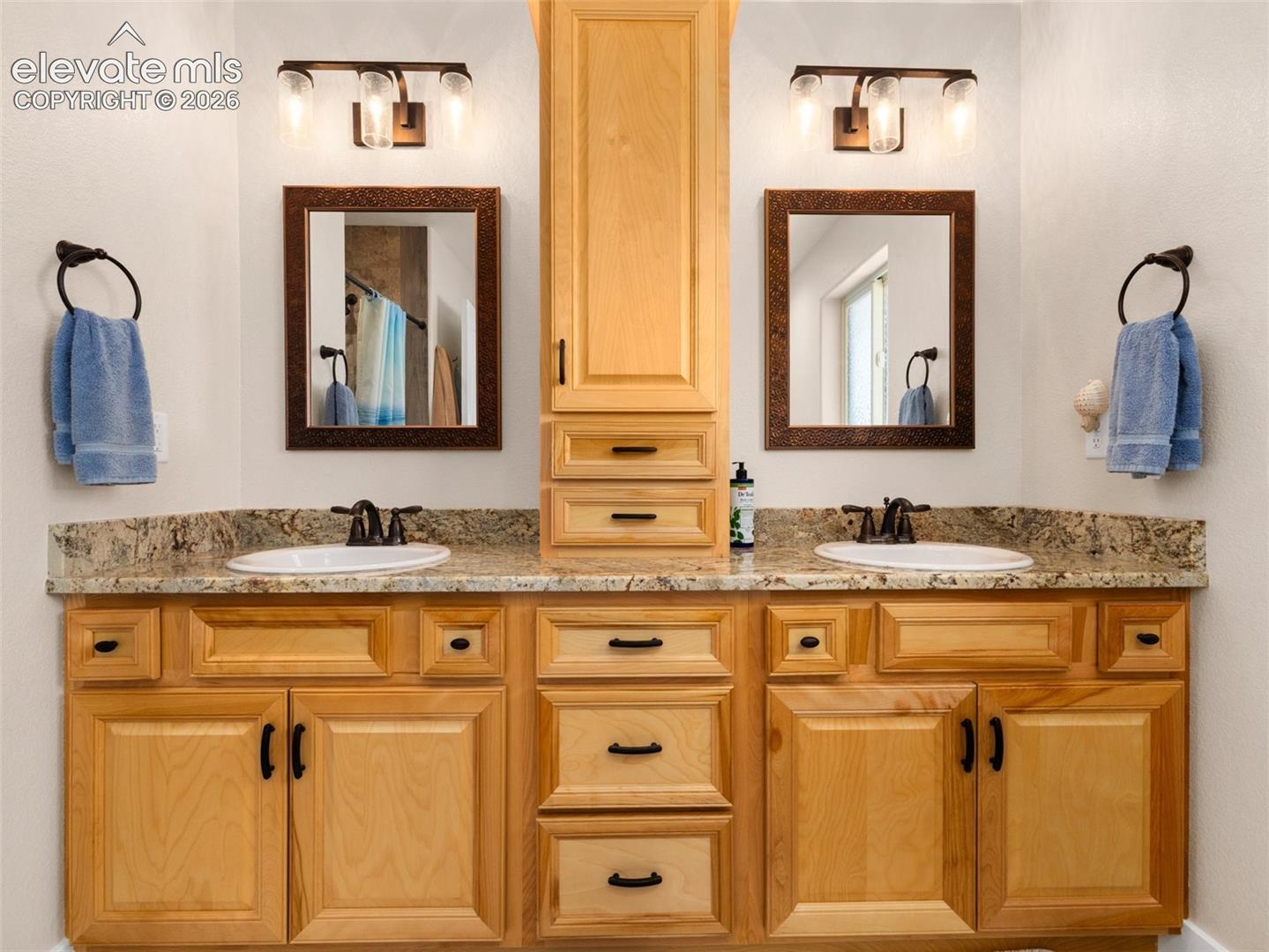Dual vanities with integrated white sinks and bronze-finish faucets