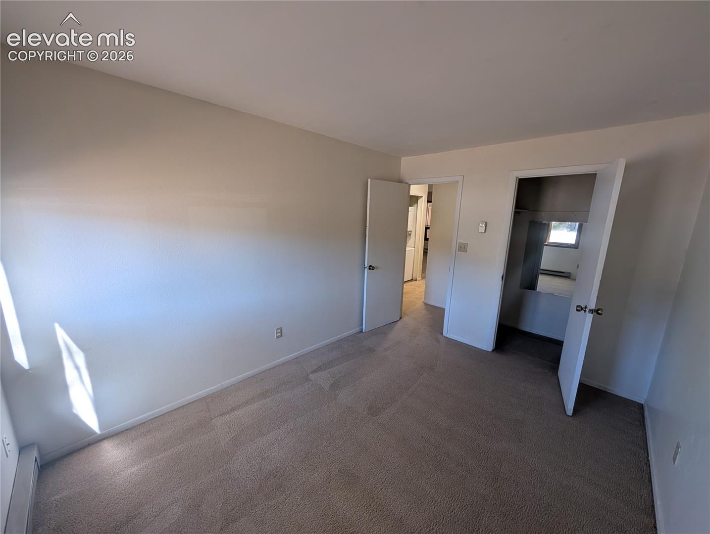 Wall-to-wall carpeting, neutral wall finishes, and solid core doors