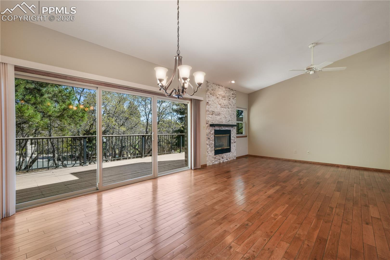 Main living room with hardwood floors, gas fireplace, extended patio doors to private deck