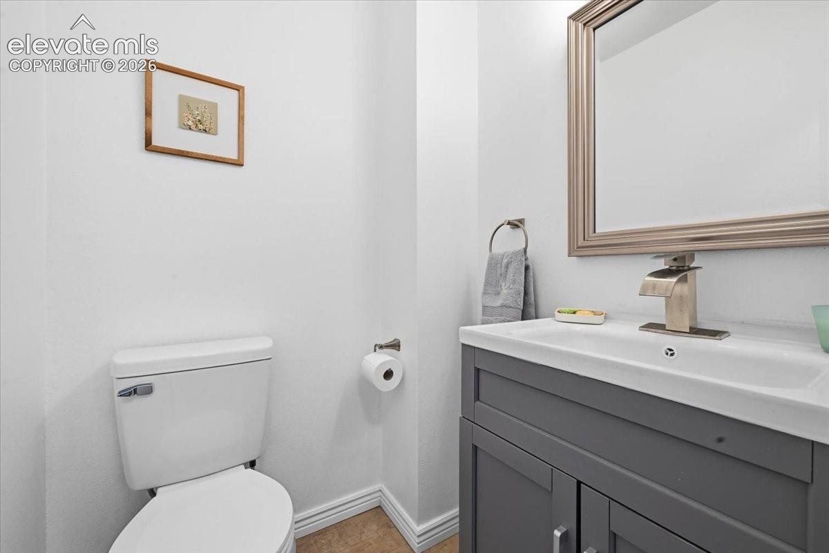 Vanity with integrated sink, brushed nickel faucet, framed mirror, and toilet