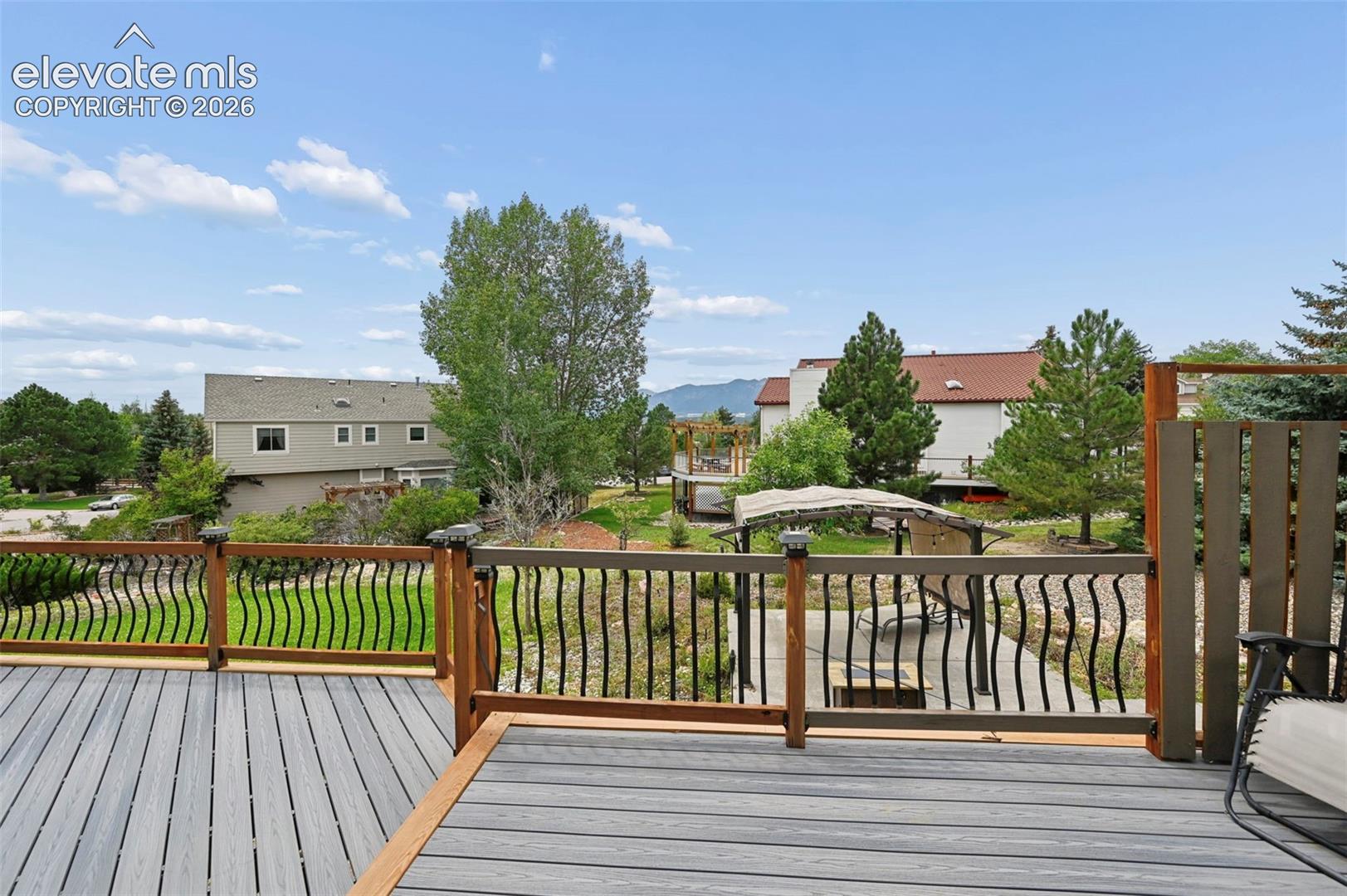 Expansive composite deck featuring wood-finish railings with decorative black spindles
