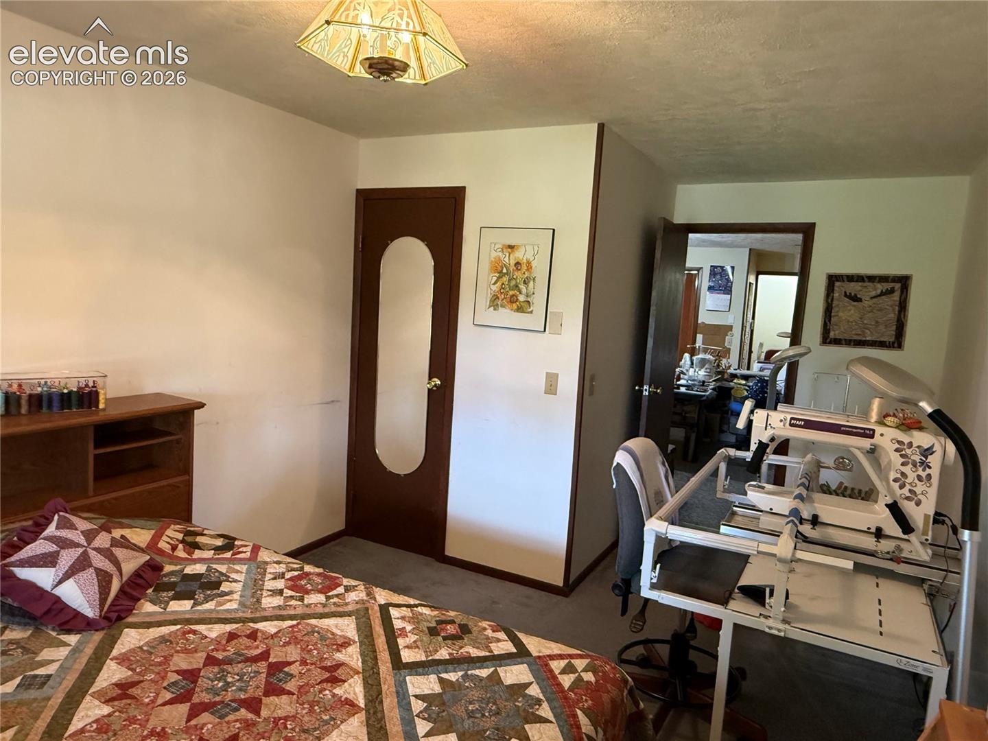 Interior room featuring neutral wall paint, gray carpet flooring, and a decorative ceiling light fixture