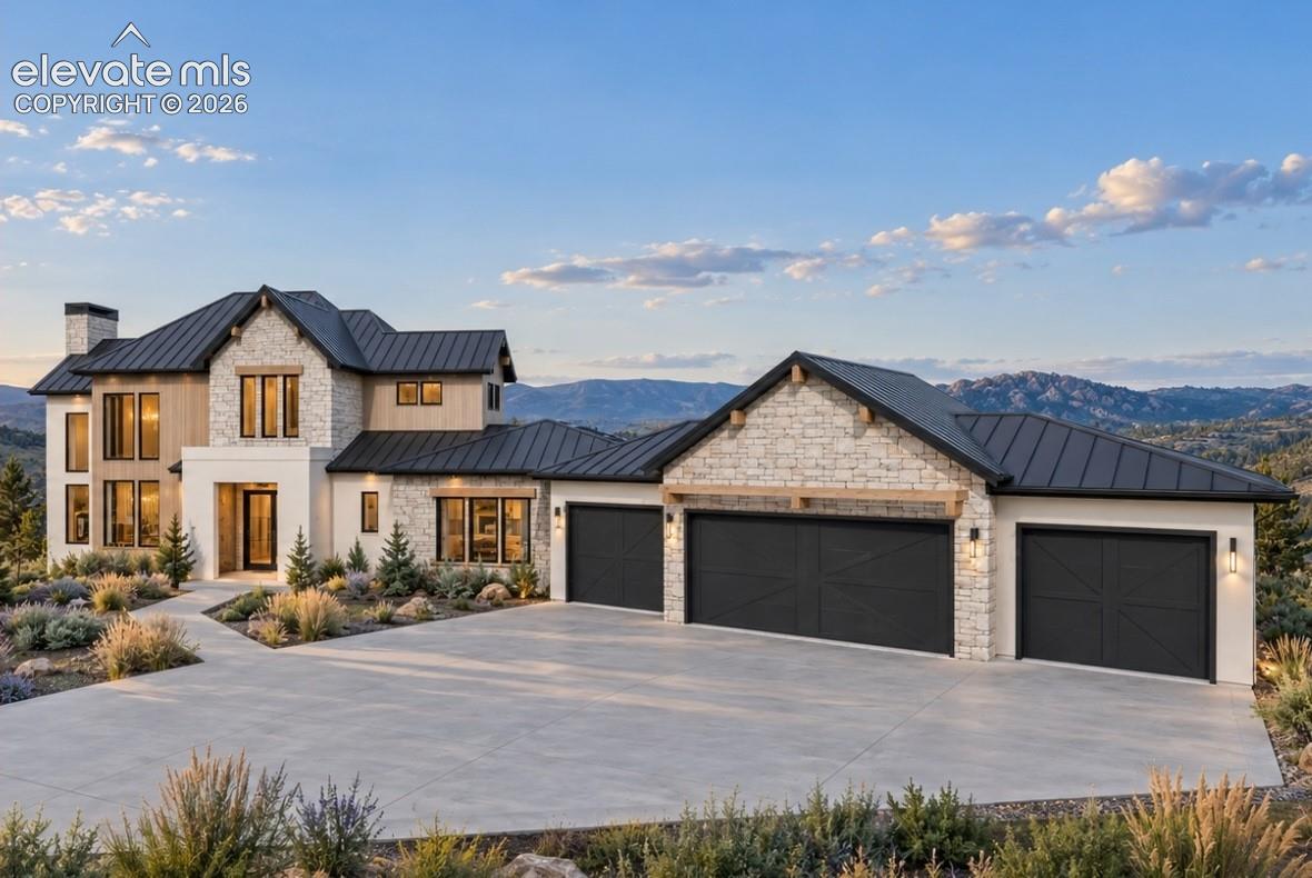 Hill Country Contemporary  architectural design with a metal roof, stone and wood-finish siding, multiple large windows, and a concrete driveway