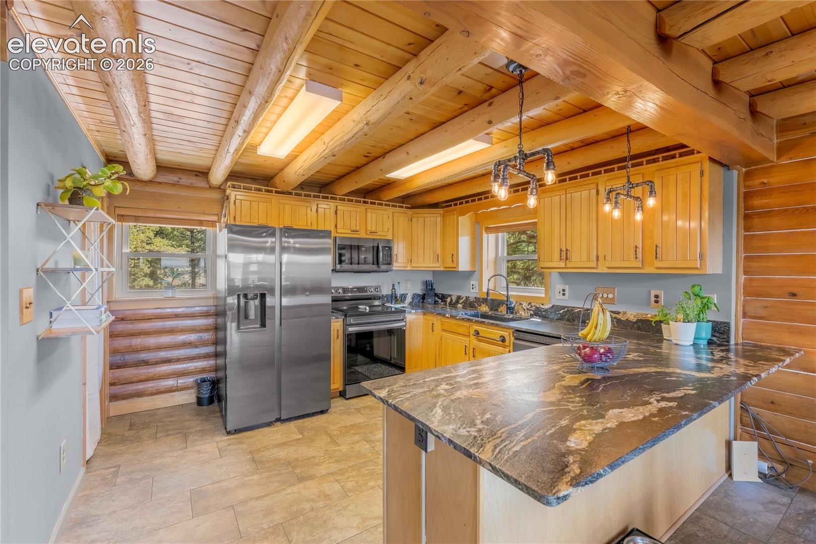 Kitchen featuring a wood plank and beam ceiling, stainless steel appliances, wood cabinetry, stone countertops, and tile flooring
