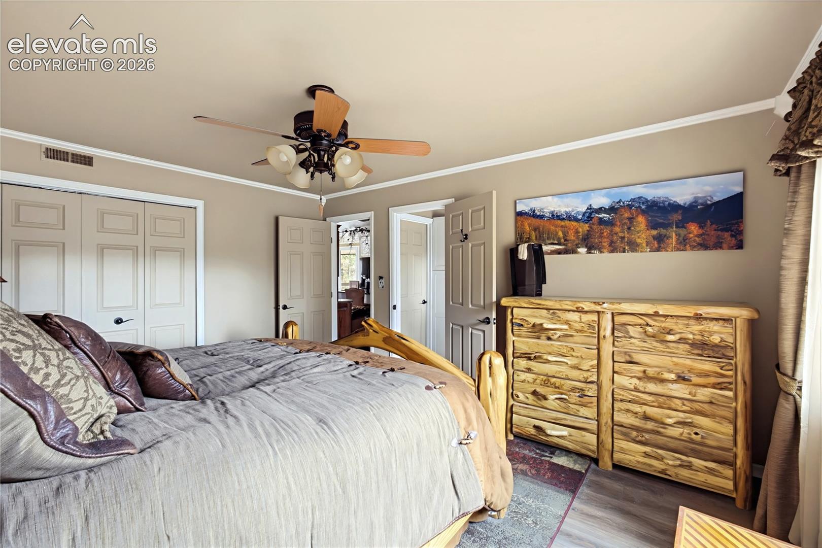 Room featuring wood-finish flooring, a multi-light ceiling fan, and paneled closet doors