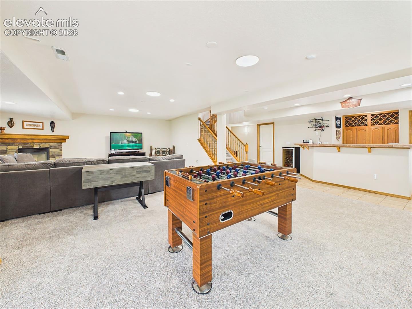 Expansive lower level with a dedicated game area, cozy fireplace seating, and a built-in wet bar for effortless entertaining.