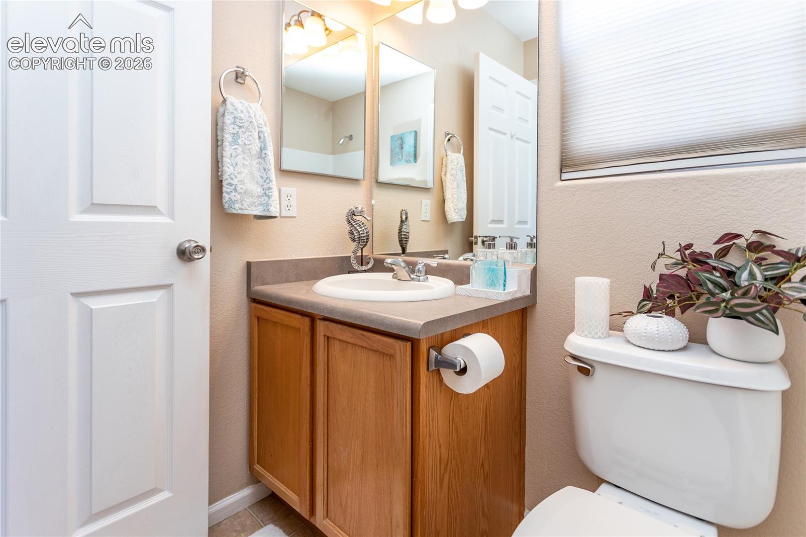 An en-suite vanity with an oak cabinet and single sink provides a private bath space in the primary suite