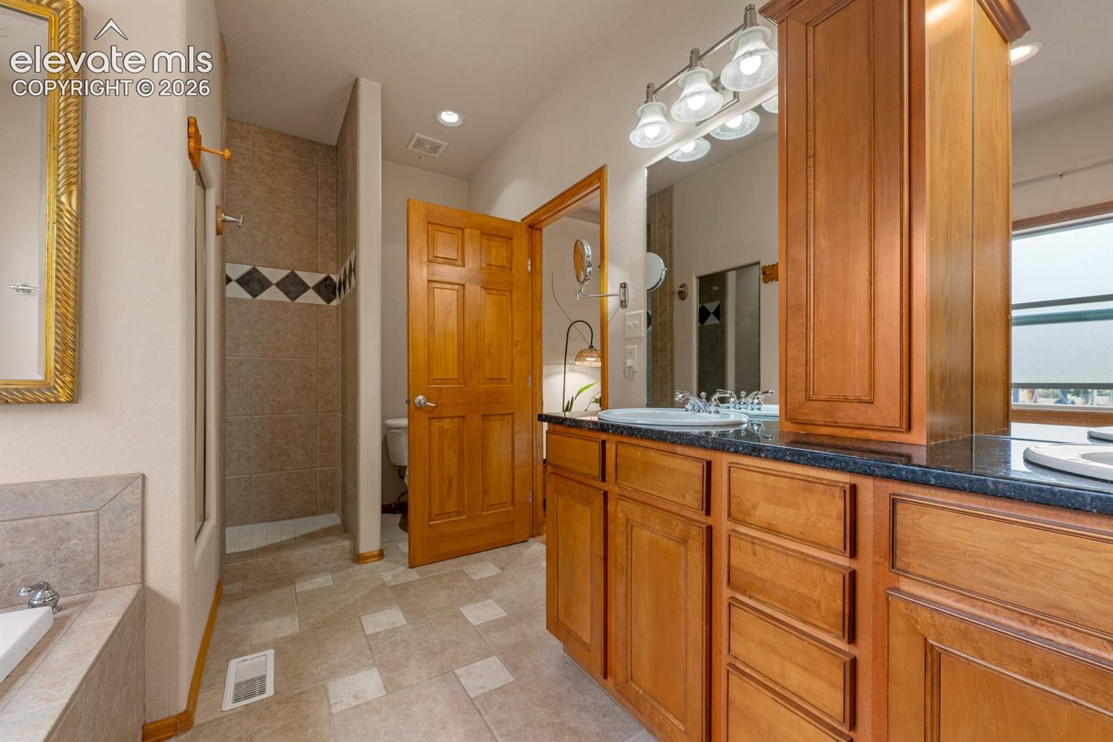 Step into a large walk in or roll shower.  Beautiful custom tile work.
