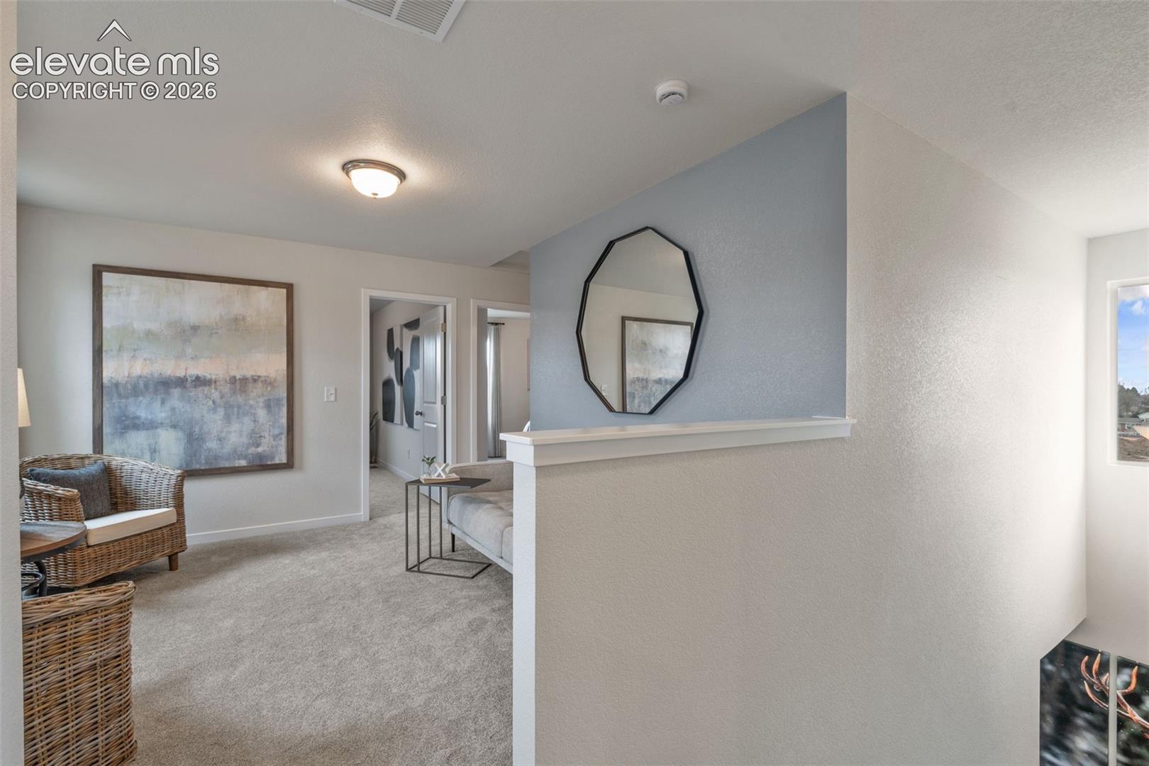 Carpeted flooring, recessed ceiling lighting, light-toned wall finishes, and a window providing natural light
