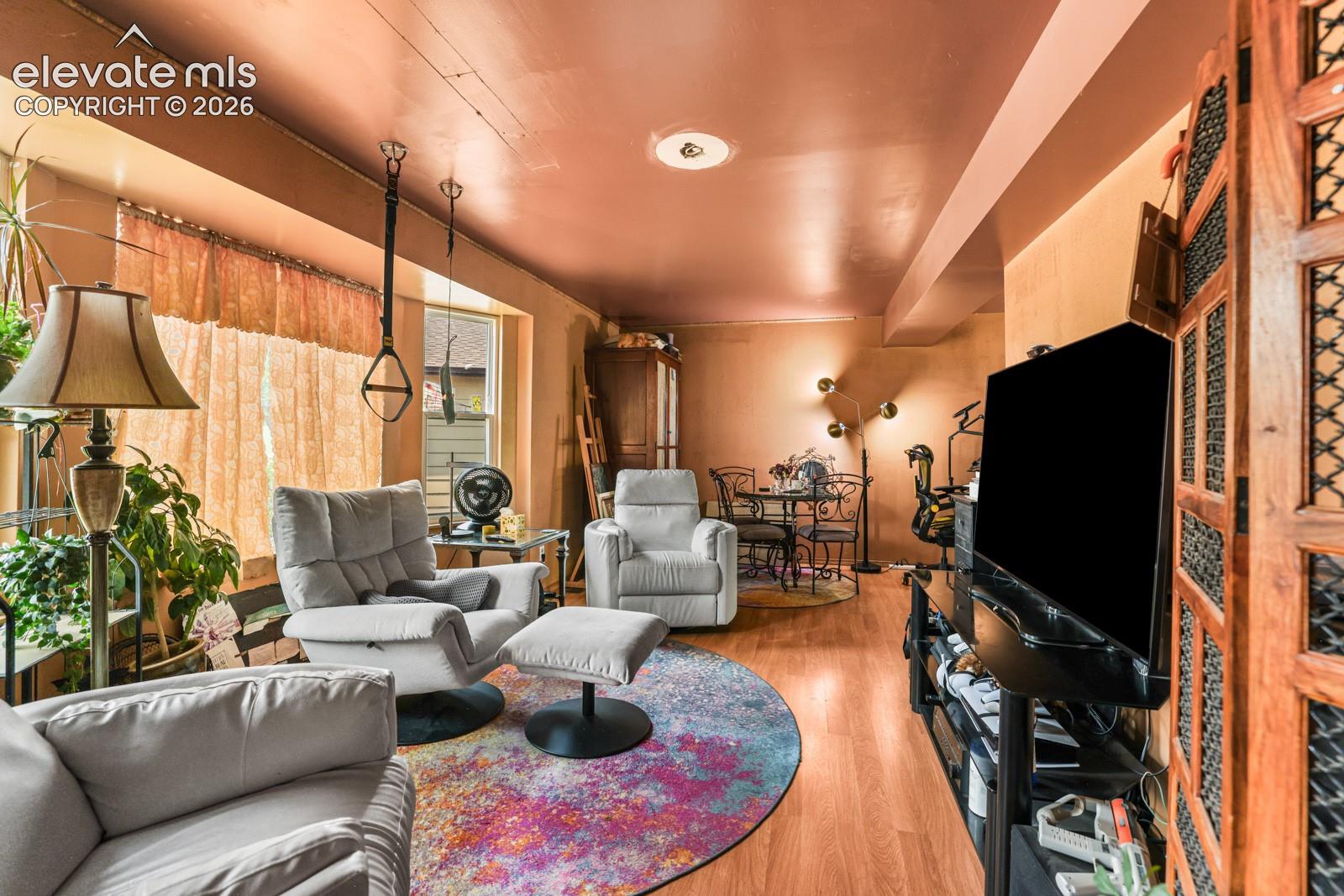 Expansive living area featuring warm-toned walls, wood-finish flooring, and a recessed ceiling light
