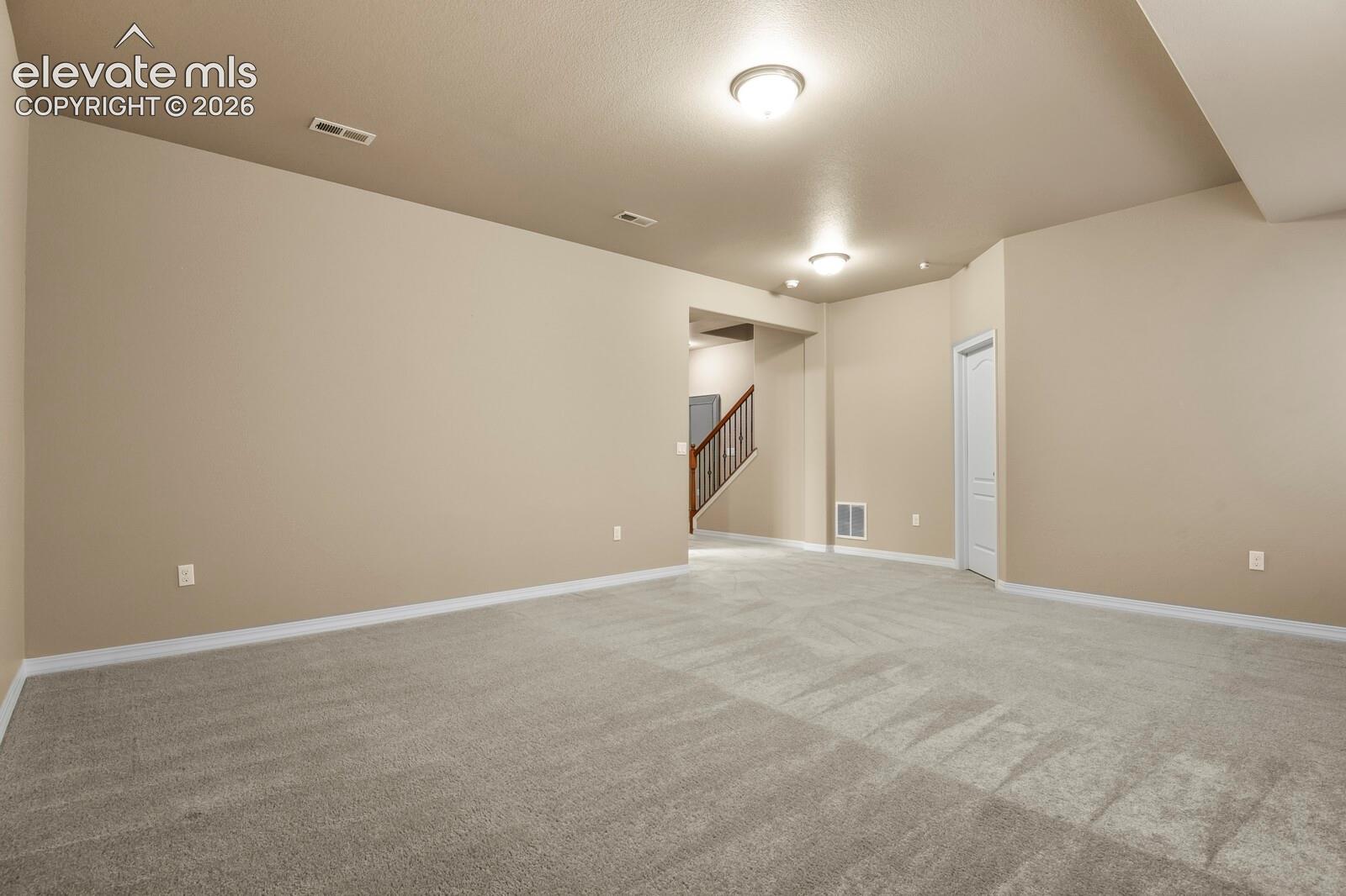 Spacious interior featuring light-toned walls, neutral carpeting, and overhead lighting