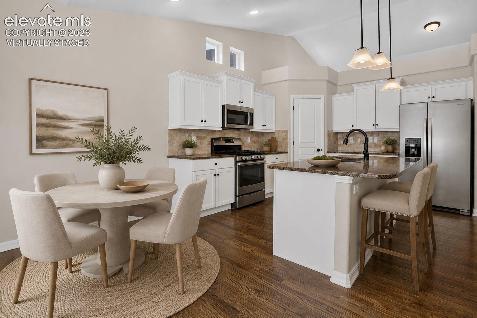 Virtually Staged - Wood-finish flooring, white cabinetry with dark hardware, stainless steel appliances, granite countertops, and recessed lighting Hardwood flooring, white cabinetry, stainless steel appliances, granite countertops, and a kitchen island with pendant lighting