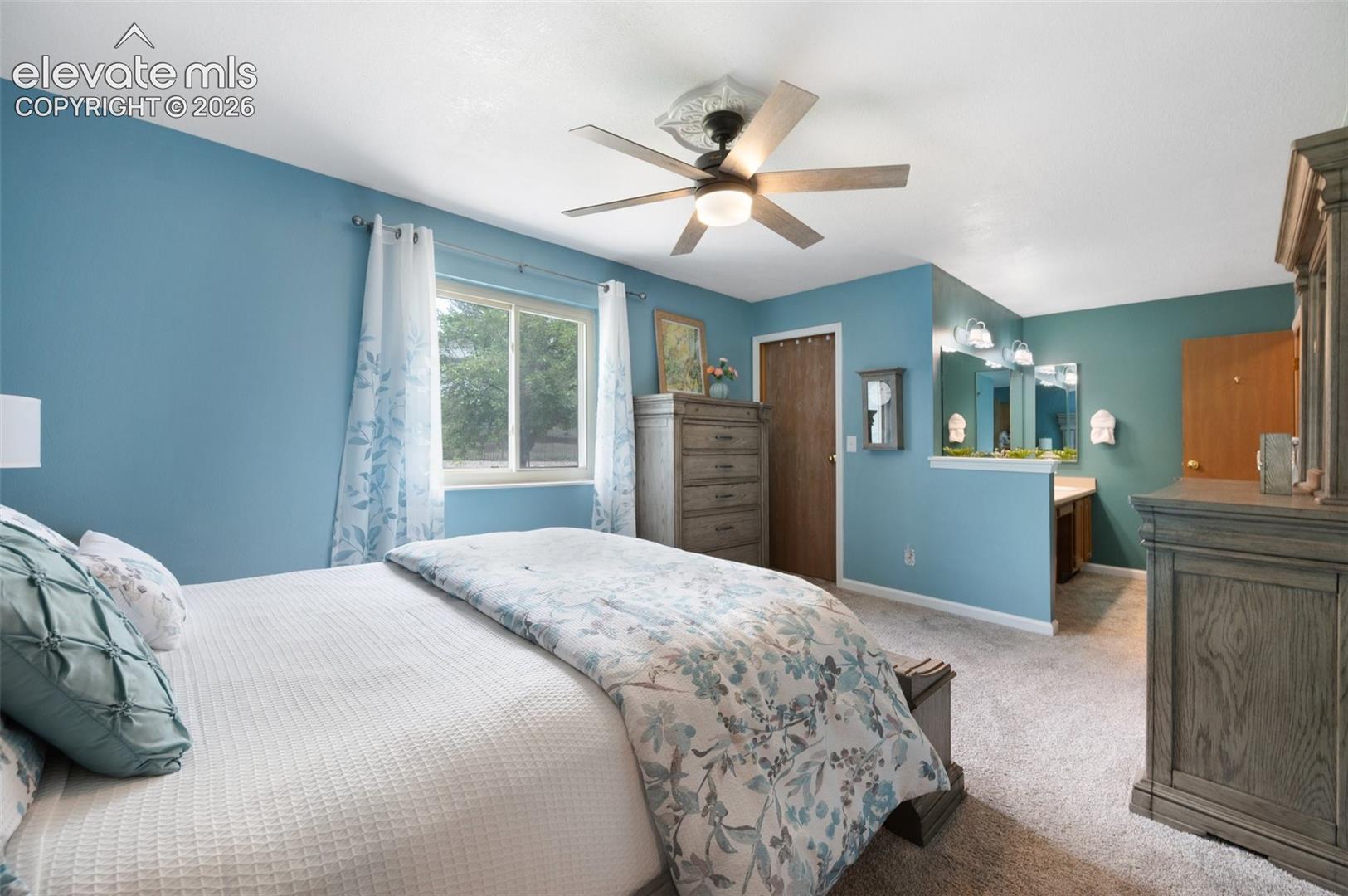 Bedroom with light carpet, baseboards, a closet, and a ceiling fan