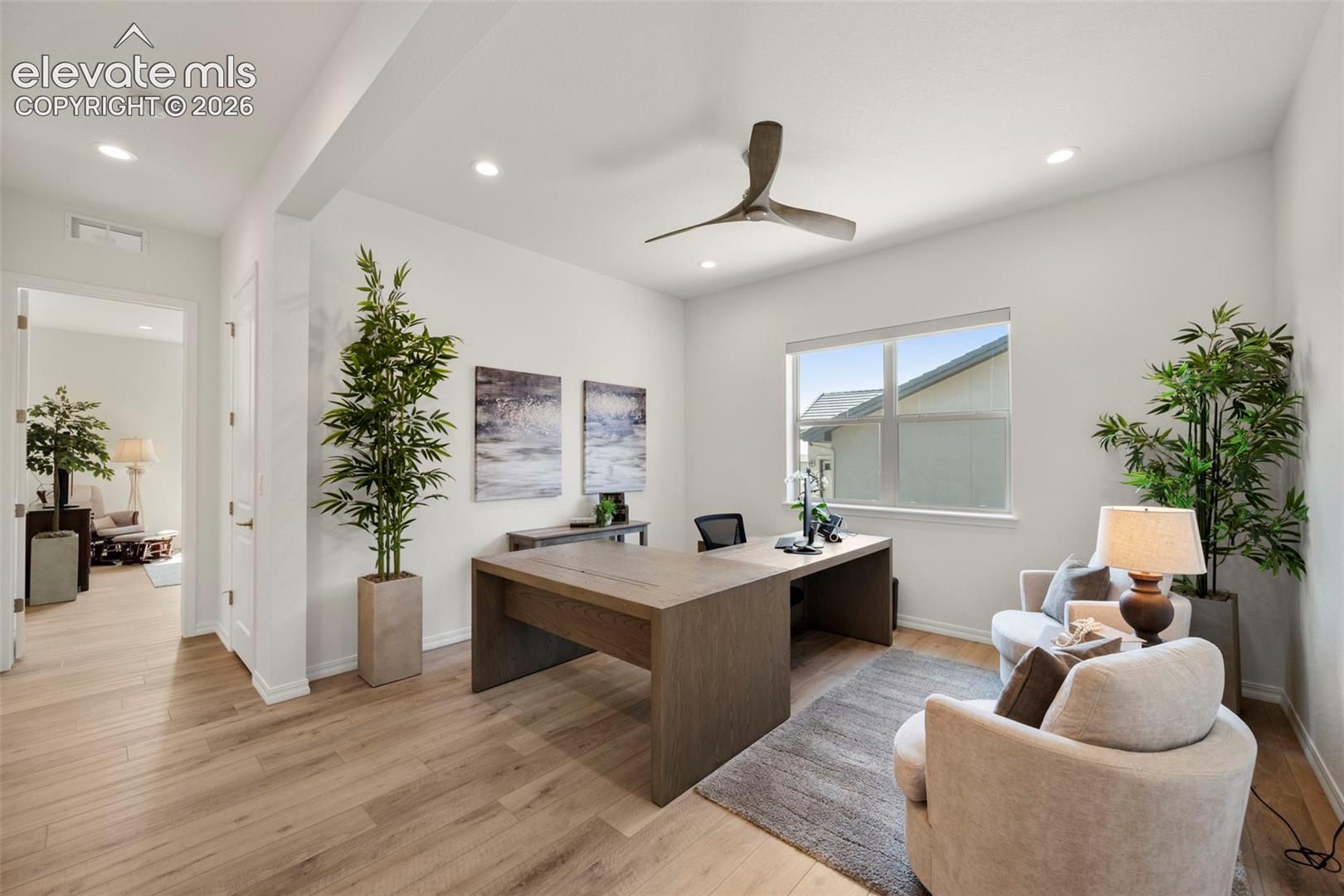 Recessed lighting, wood-finish flooring, a contemporary ceiling fan, and a large window with roller shades