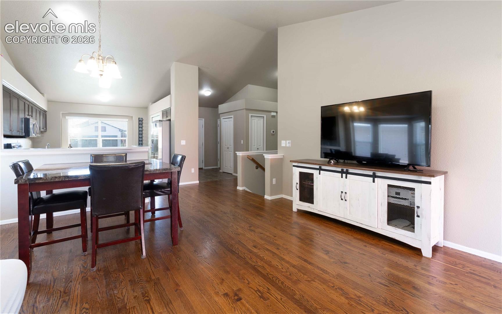 Open-concept interior featuring vaulted ceilings, wood-finish flooring, and recessed lighting