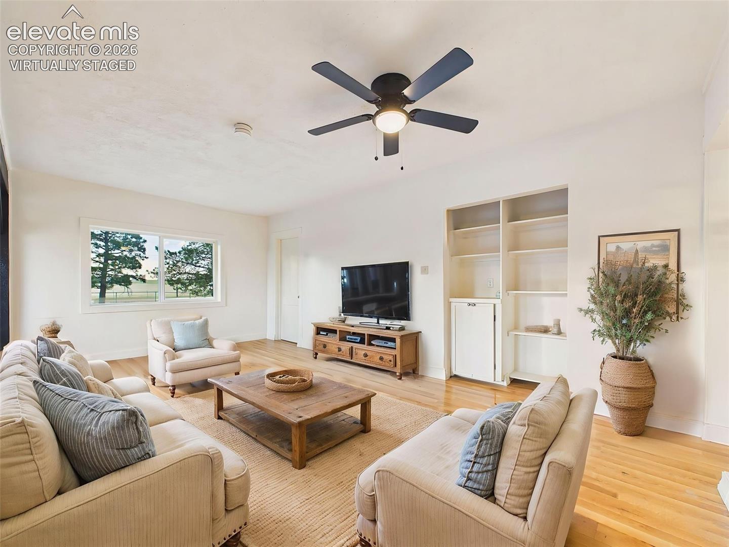 (Virtually Staged) Living Area – Open gathering space features beautiful flooring, updated lighting, and architectural beam details that add warmth and character.