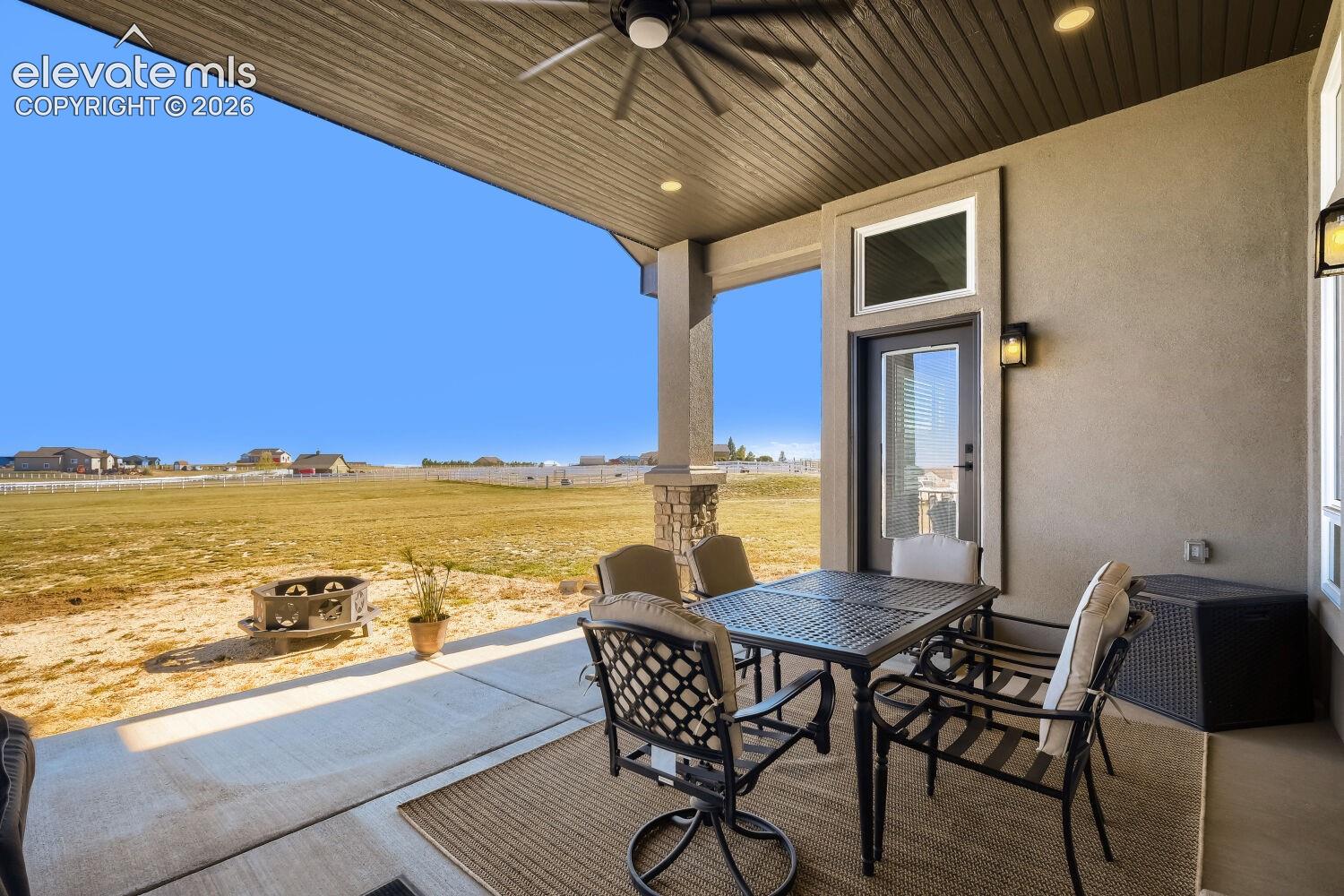 Covered patio featuring a ceiling fan, recessed lighting, exterior sconces, and a glass-paneled door