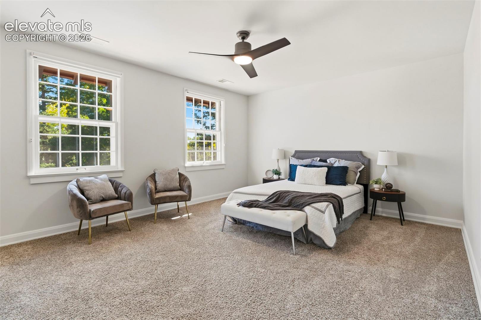 Neutral-toned carpeting, multi-pane windows, and a modern three-blade ceiling fan with integrated lighting