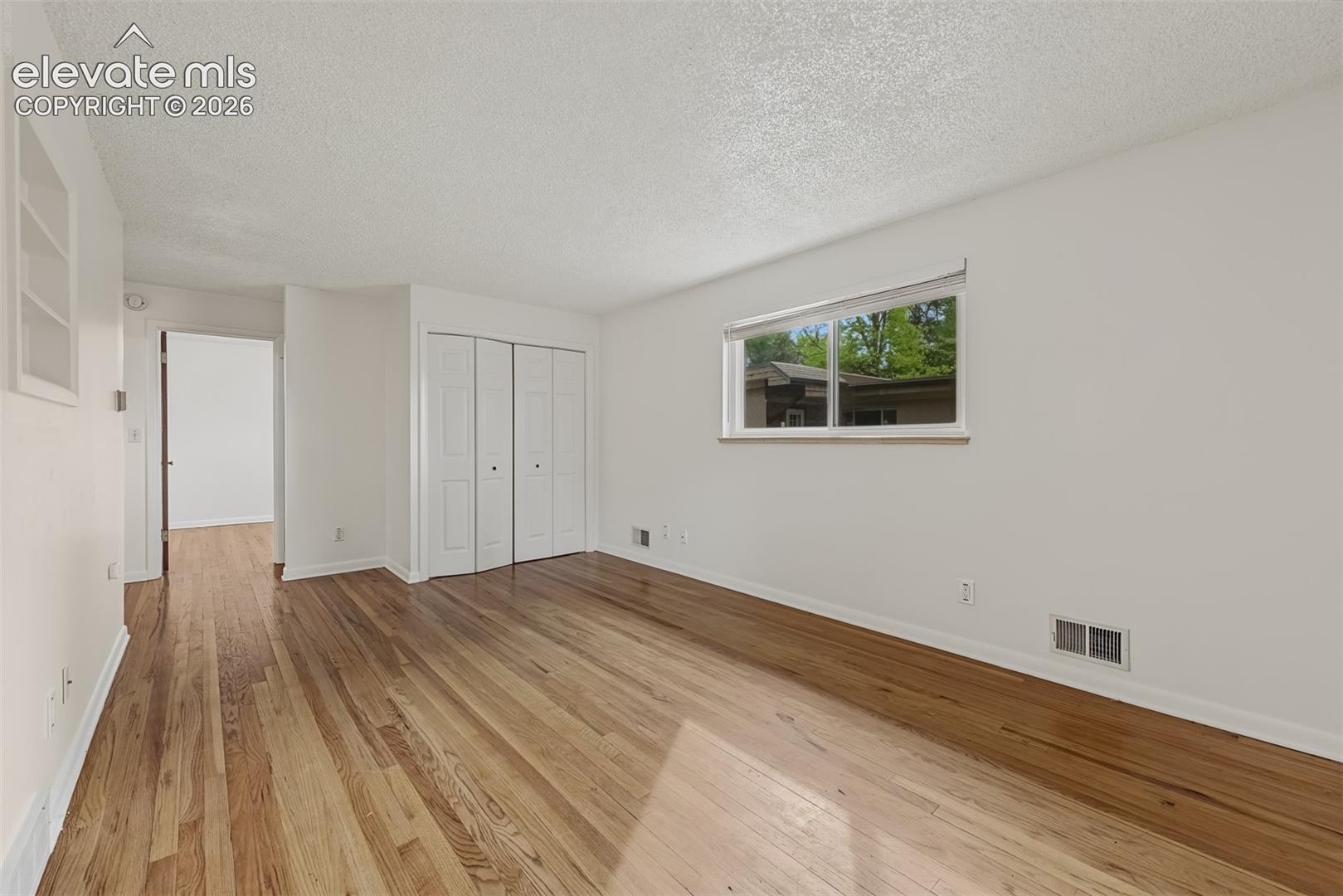 Interior space featuring wood-finish flooring, a horizontal sliding window, and a built-in recessed wall niche