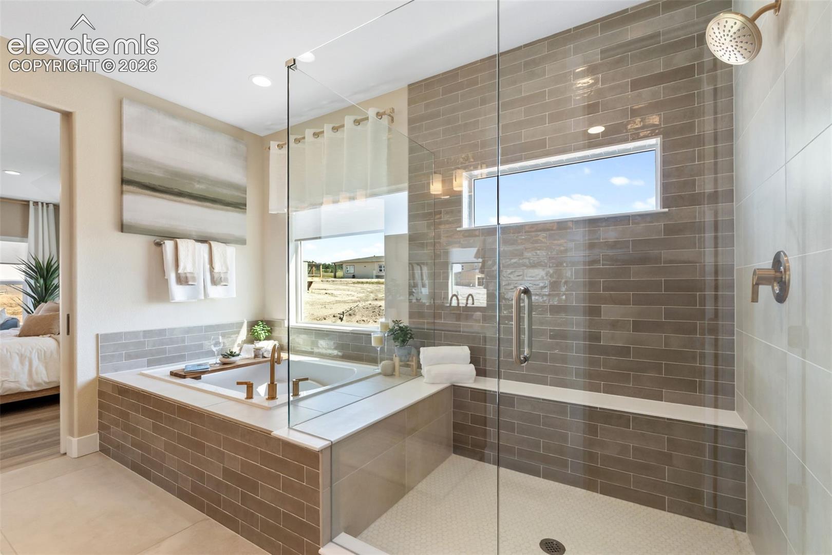 Bathroom featuring a soaking tub, glass-enclosed walk-in shower with horizontal ceramic tile surround, built-in shower bench, and metal finish fixtures