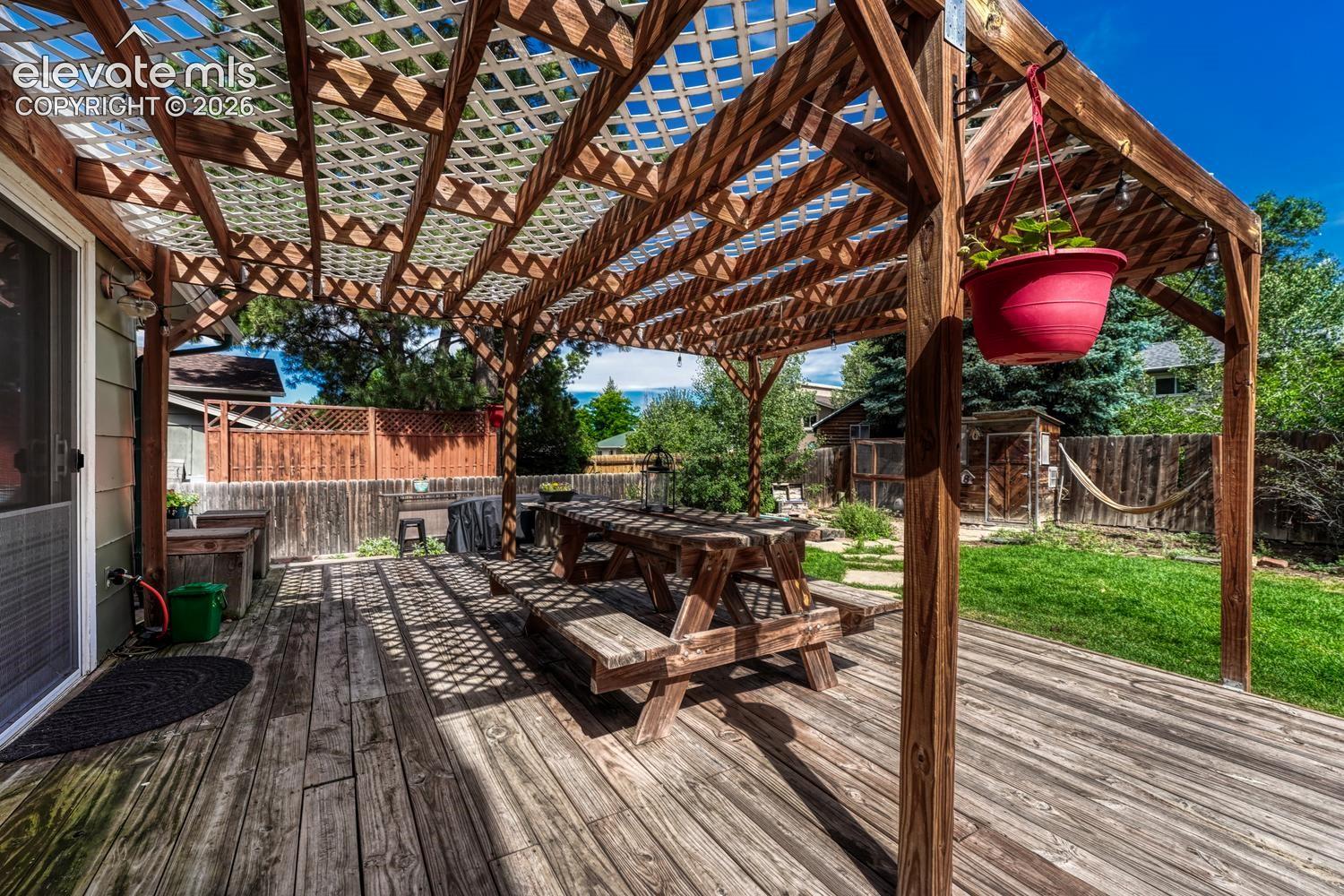 Expansive backyard deck with covered pergola for outdoor dining, entertaining, and relaxation.