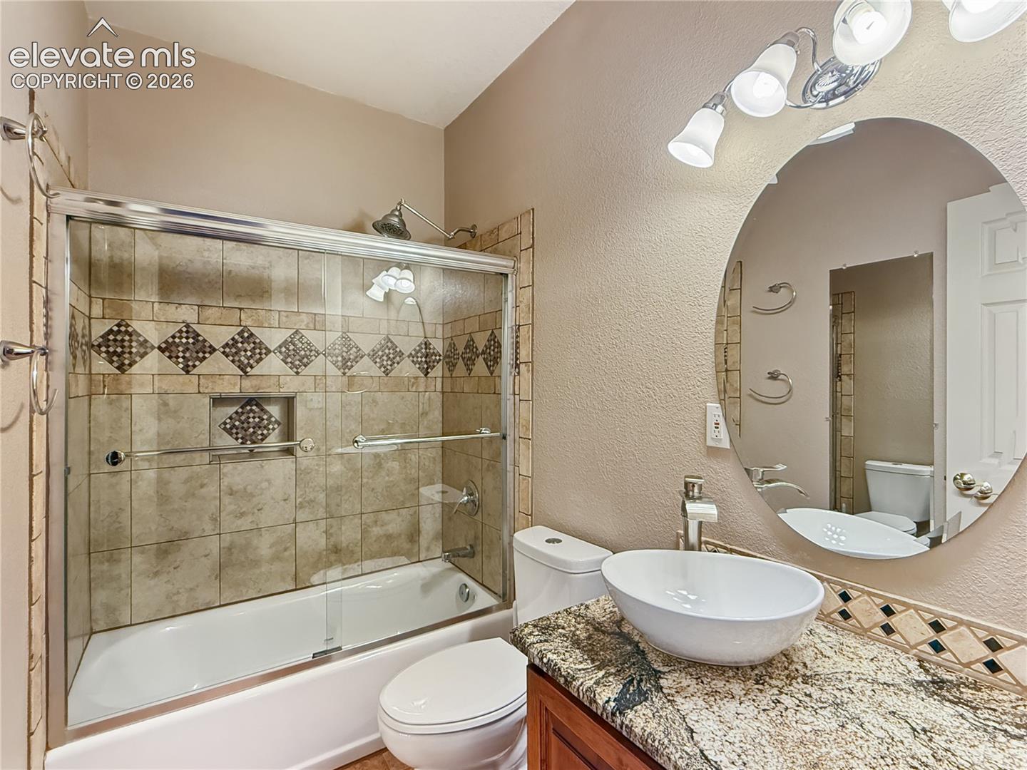 Basement bathroom with vessel sink and granite counters with an alder cabinet