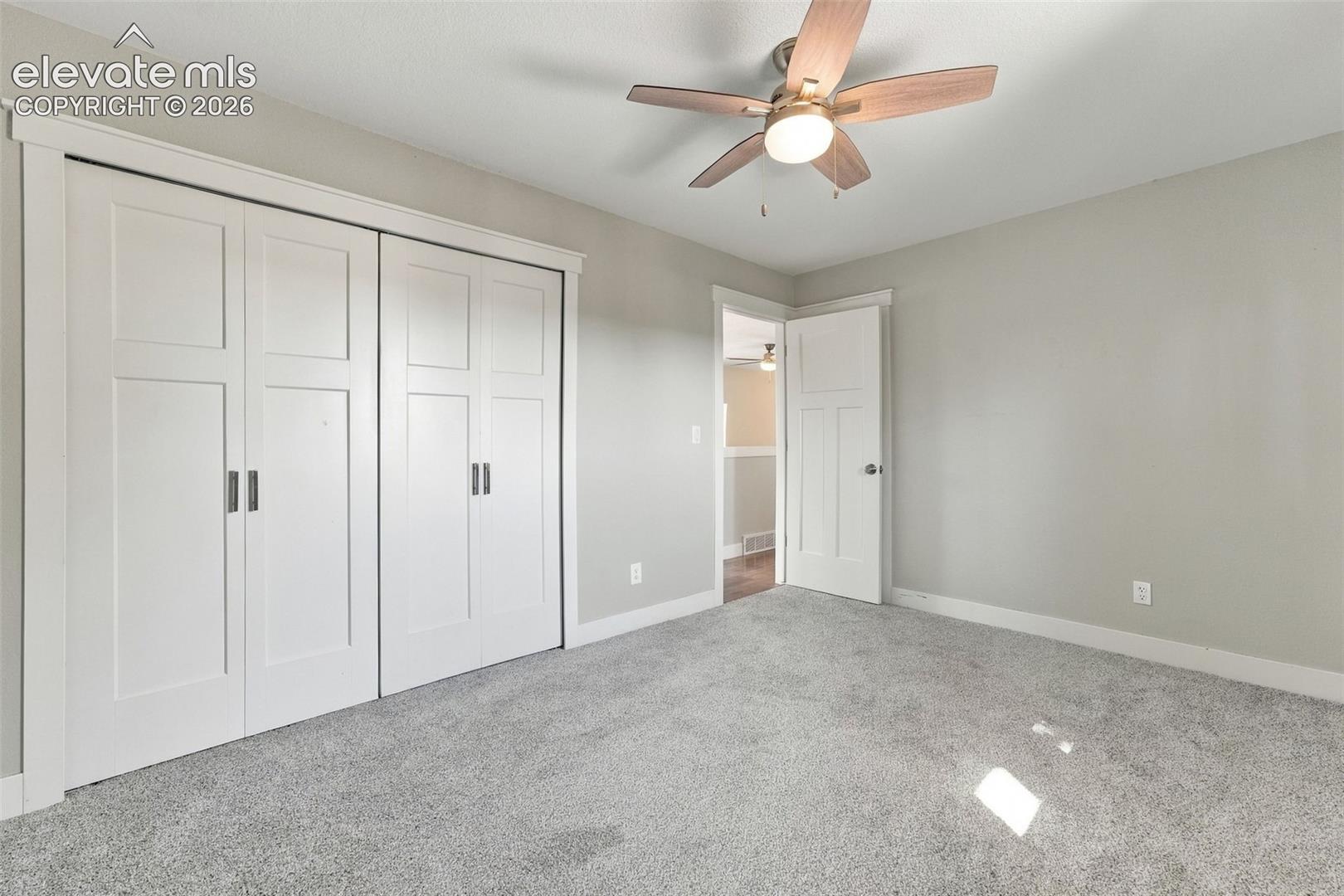 Neutral-toned walls complement the light gray carpeting