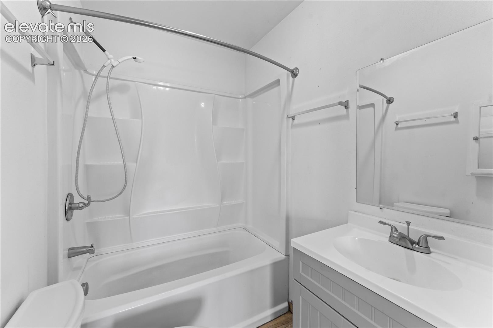 Bathroom featuring a white bathtub and shower combination with a shower curtain rod