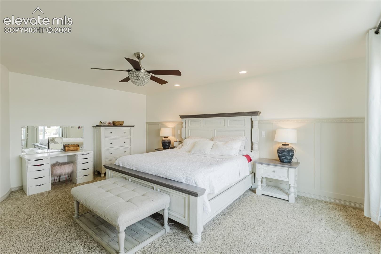 Spacious room featuring neutral carpeting and a decorative ceiling fan