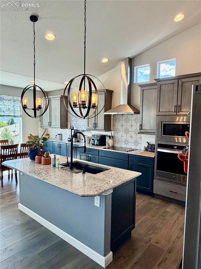 Large island with sink and lots of lighting